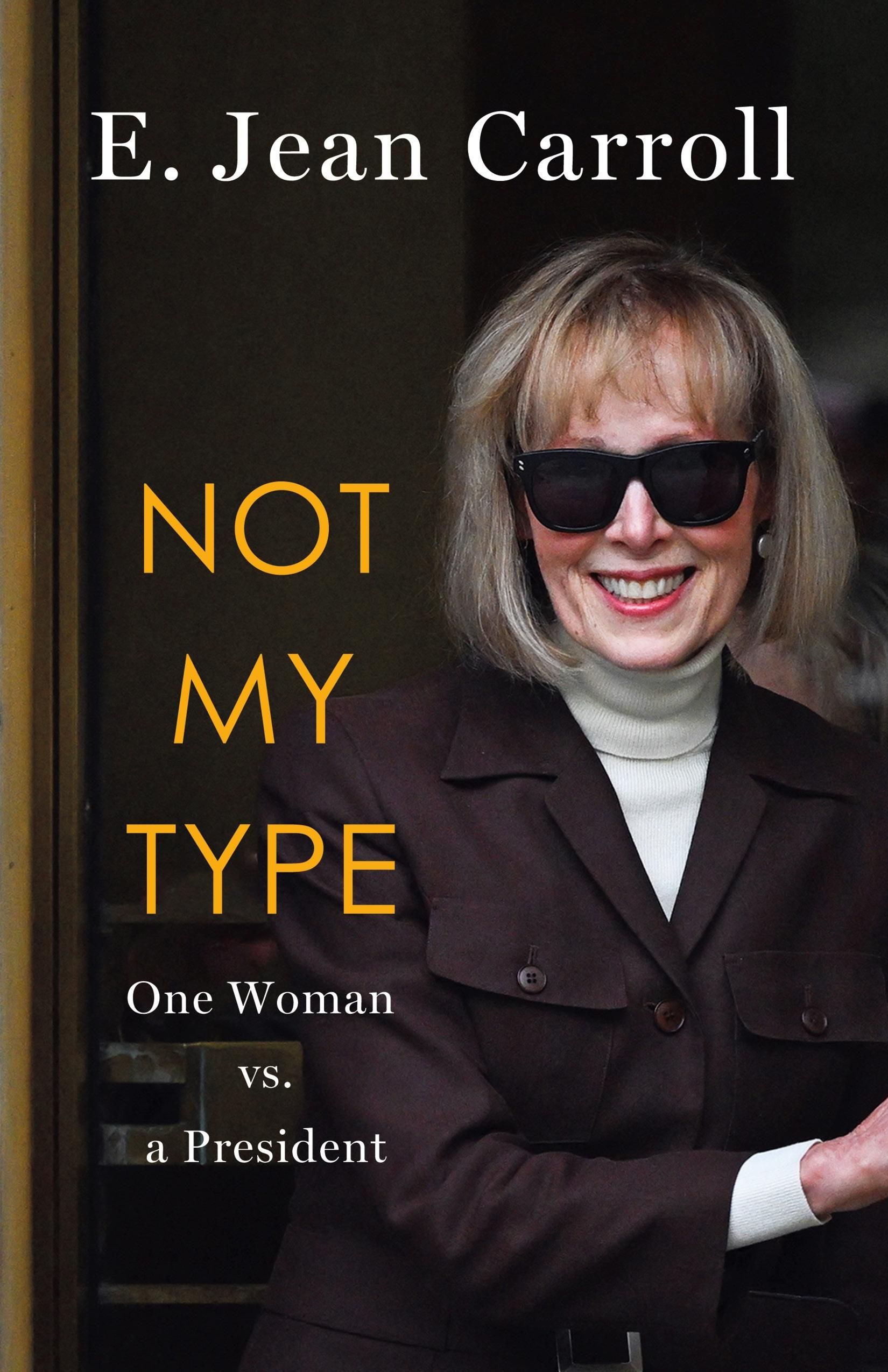 Book cover for Not My Type by E Jean Carroll. Features a photo of the author wearing a white turtleneck, brown jacket, sunglasses, and a broad smile. 