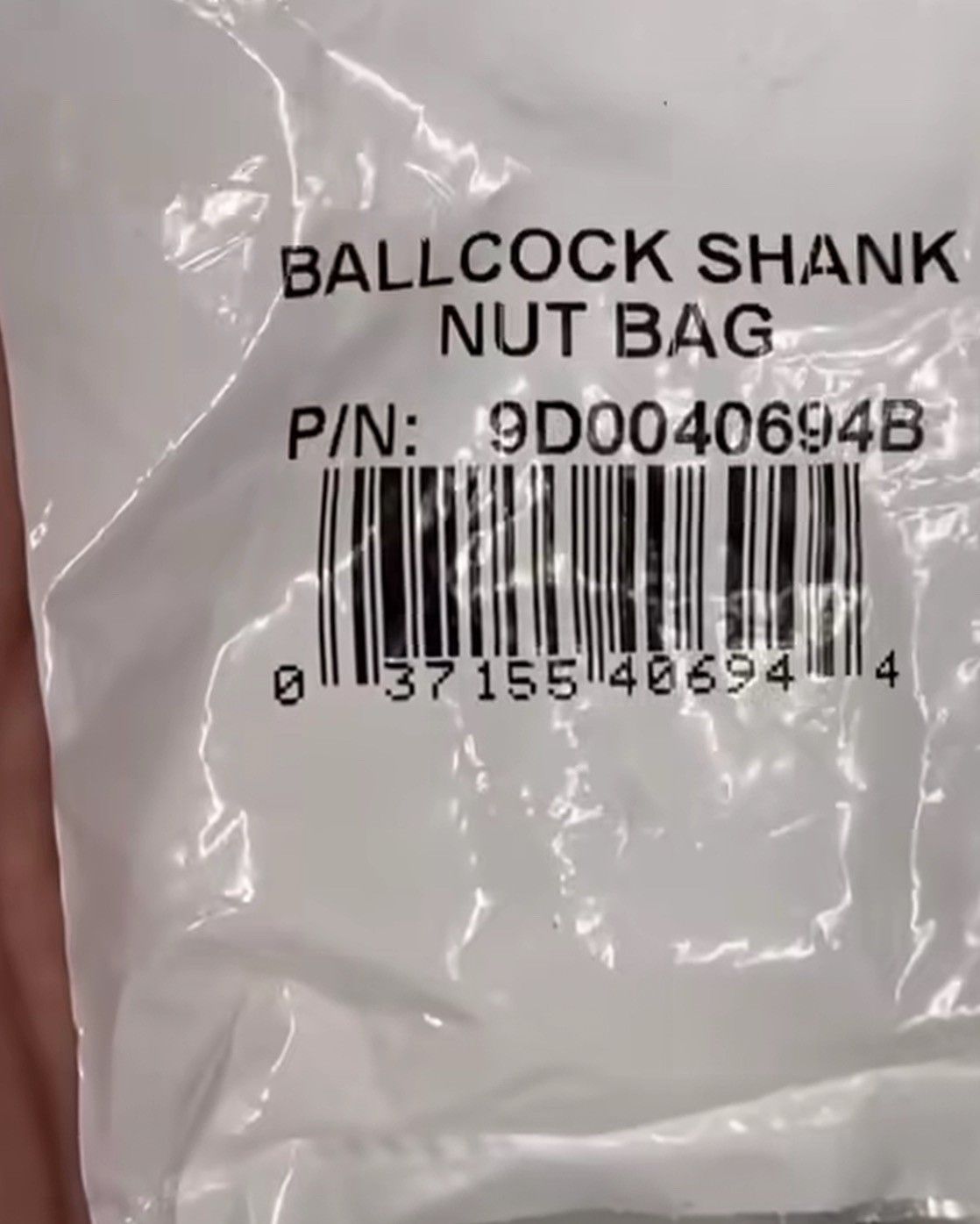 Photo of a white plastic bag with a UPC bar code. The text of the product name reads “BALLCOCK SHANK NUT BAG.”