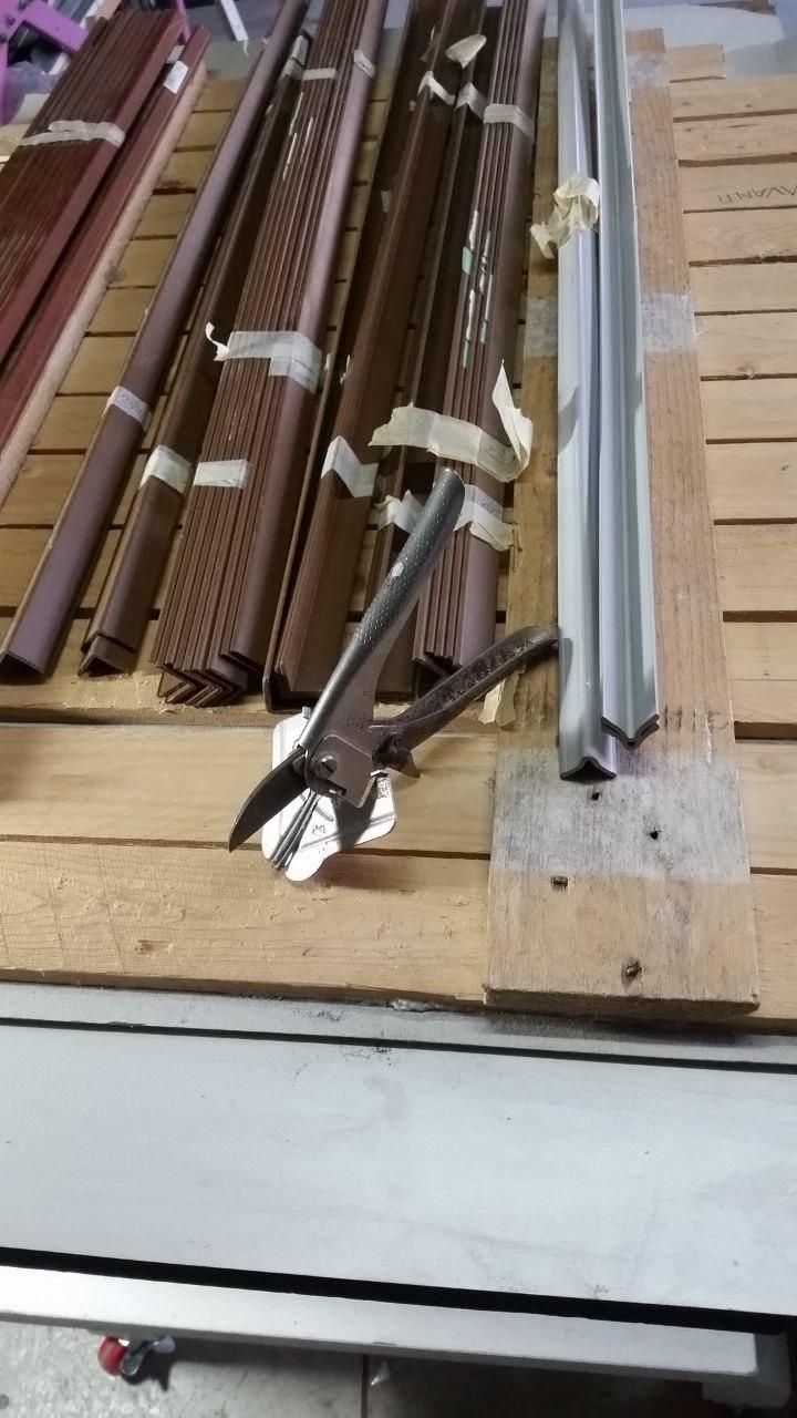 Cesoia tagliabordini con guida per fare tagli angolati a 45°.
Dietro vari paraspigoli, in legno e PVC, che serviranno per finire i piani del tavolo.