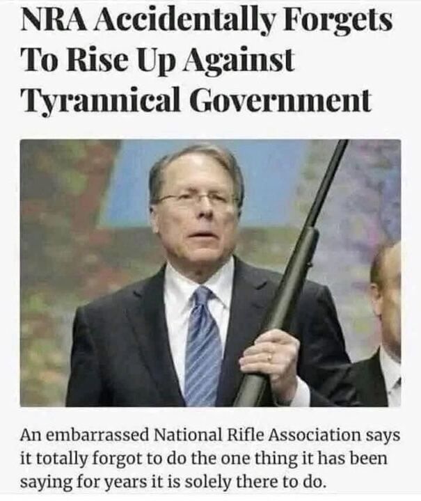 A satirical image with the headline "NRA Accidentally Forgets To Rise Up Against Tyrannical Government." The text below reads, "An embarrassed National Rifle Association says it totally forgot to do the one thing it has been saying for years it is solely there to do." The image shows a man in a suit and tie holding a rifle, with another person partially visible in the background. The tone and content suggest a humorous critique of the NRA.
