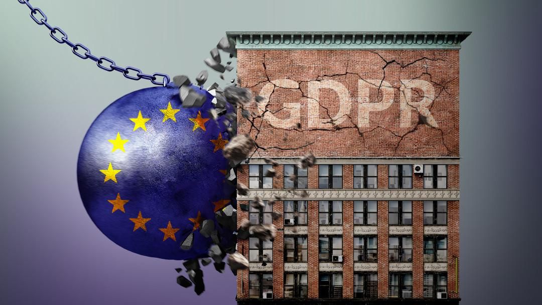 A blue wrecking ball with EU stars is crashing into a brick house with the letters "GDPR" written on it. There are visible cracks in the facade of the house.
