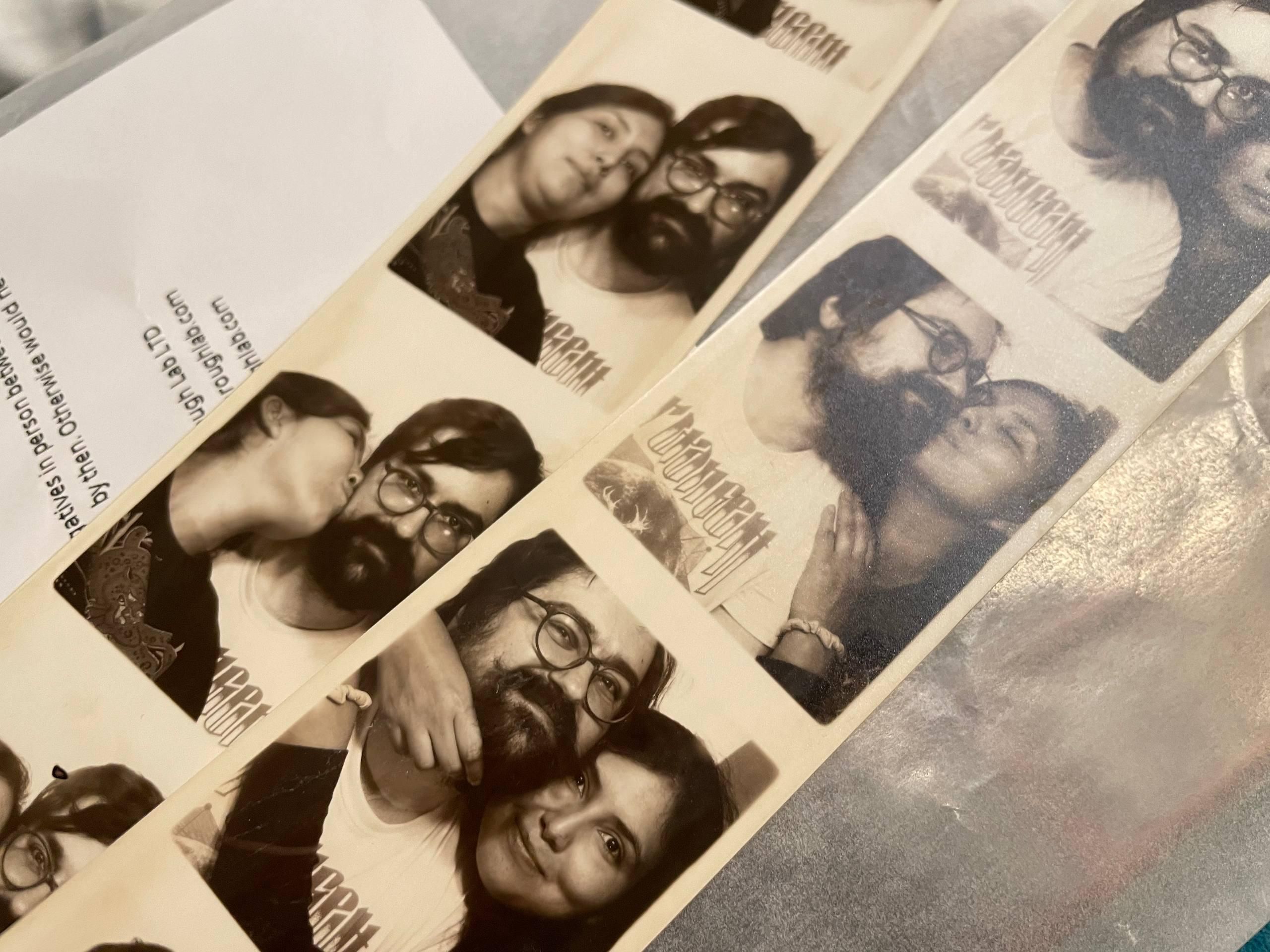 A close up of 2 black and white photo strips of a man and a woman trying to fit in the frame while also posing for the camera.