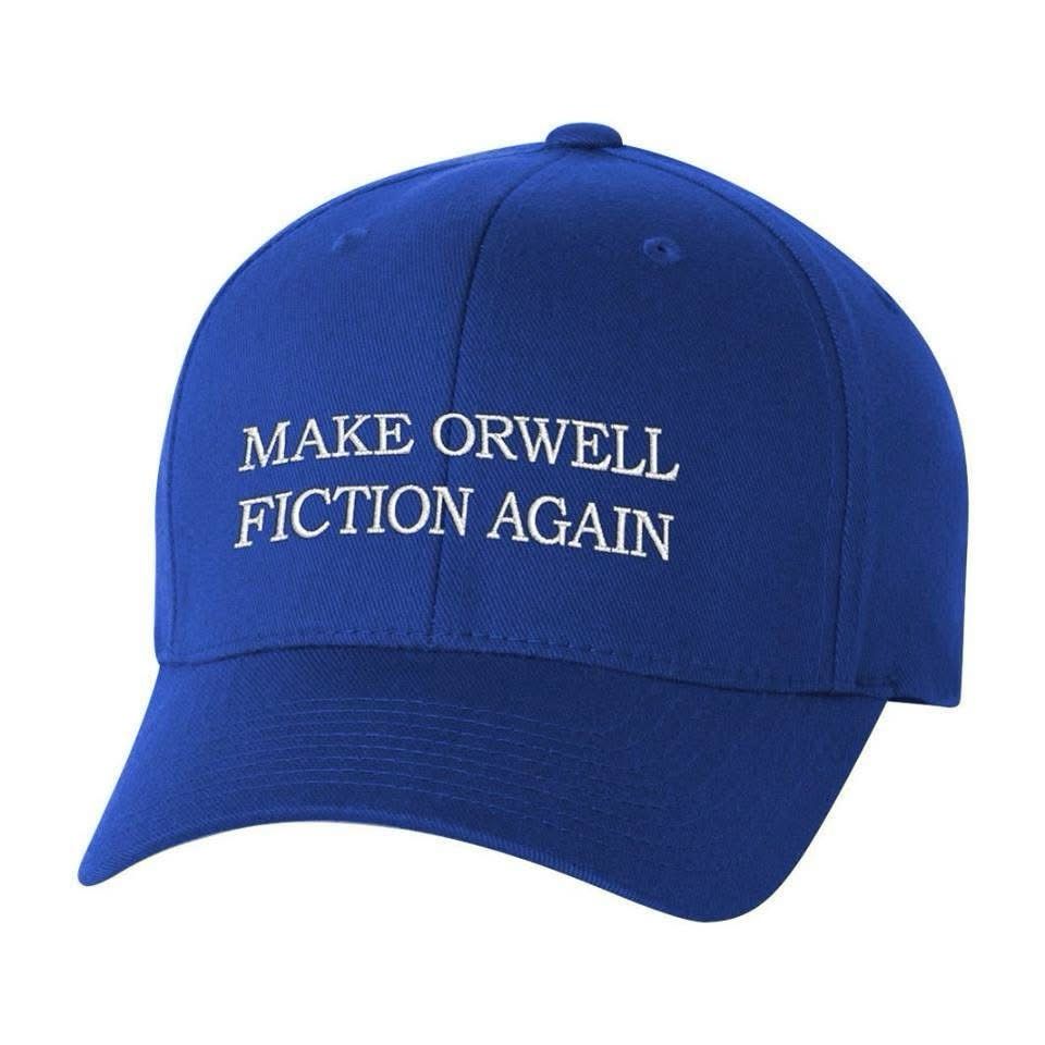 A royal blue baseball cap has MAKE ORWELL FICTION AGAIN embroidered on the front. 