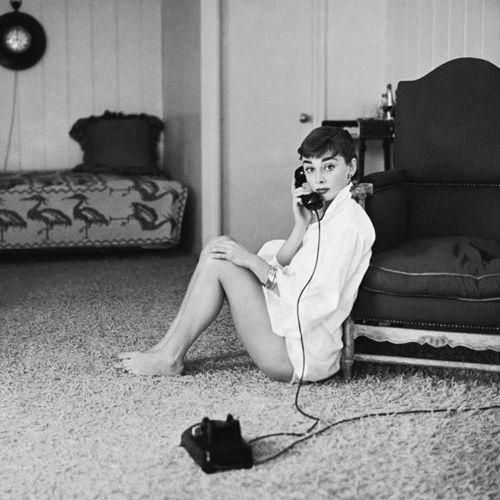 Audrey wears a men's shirt as as she sits on the floor, and talks on the telephone. 