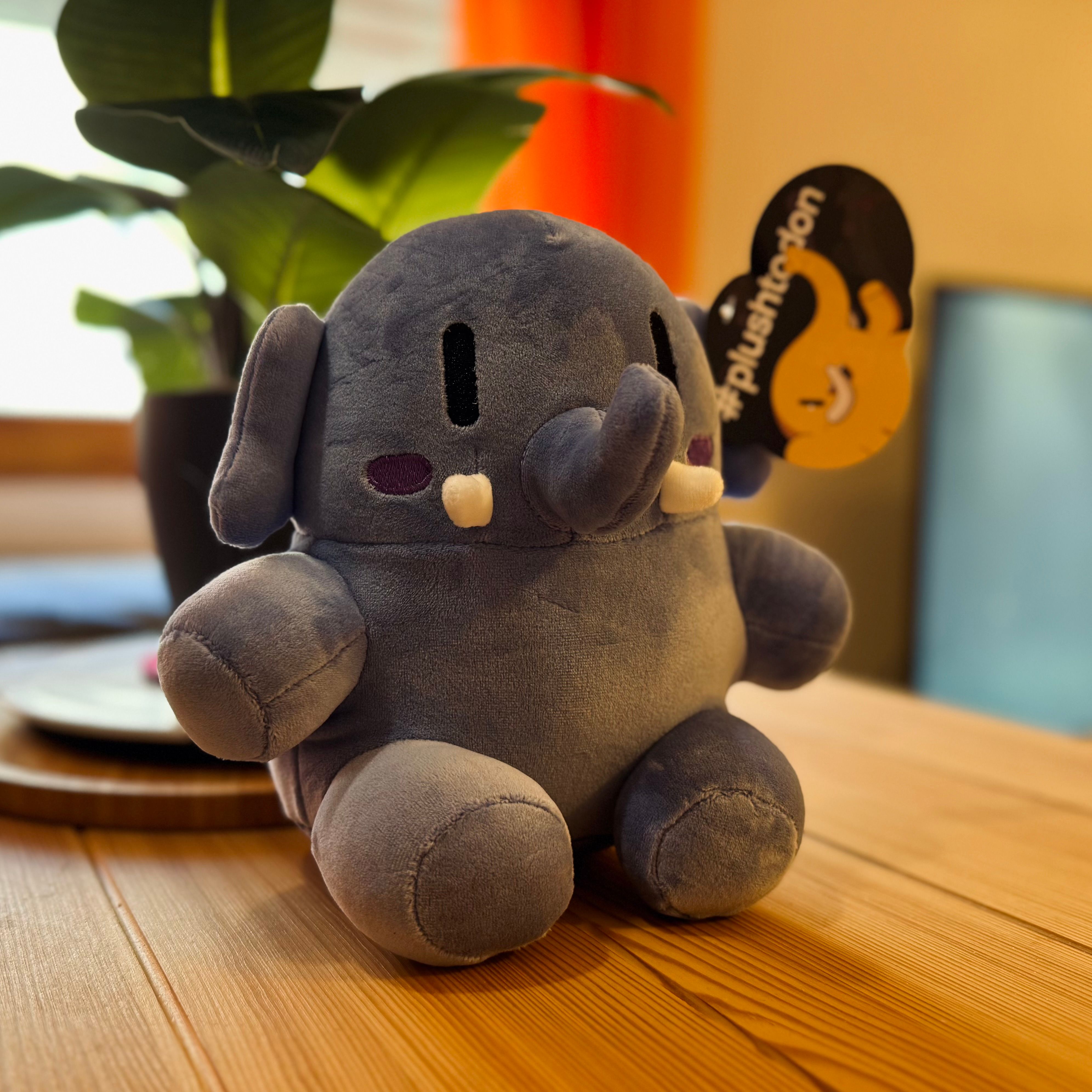Encima de una mesa está la mascota de peluche de Mastodon: elefante azul de unos 20cm de alto.
