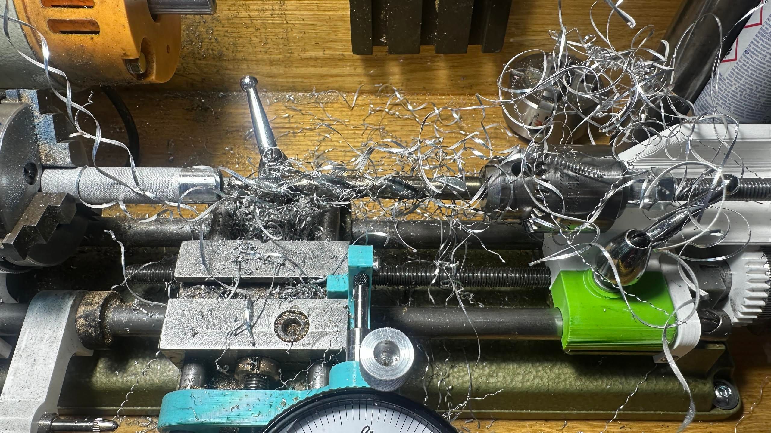 drill bit on a lathe wrapped in long strings of aluminum from boring a 50mm deep hole in a knurled part