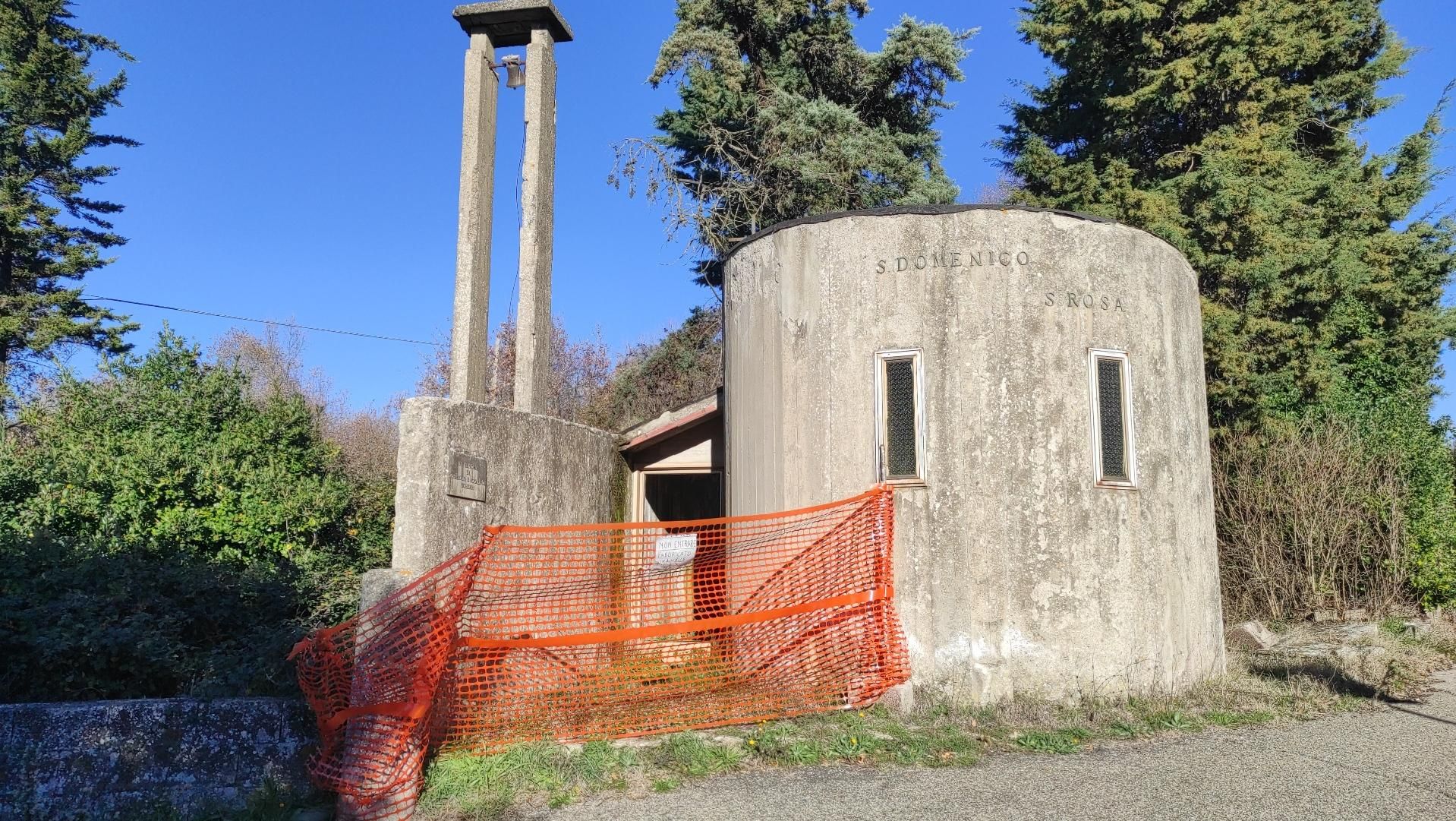torre ed edificio malandato in cemento con scritte sbiadite di S. Domenico e S. Rosa e una rete rossa da cantiere