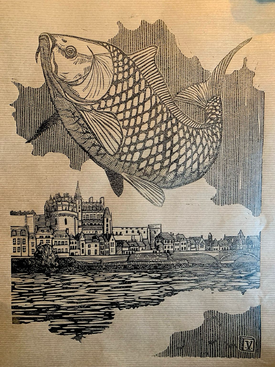 Estampe en noir sur papier craft marron d’une grosse carpe en plein saut. Derrière, une ville avec un château au bord d’un fleuve, sous un ciel ennuagé. L’encrage est approximatif