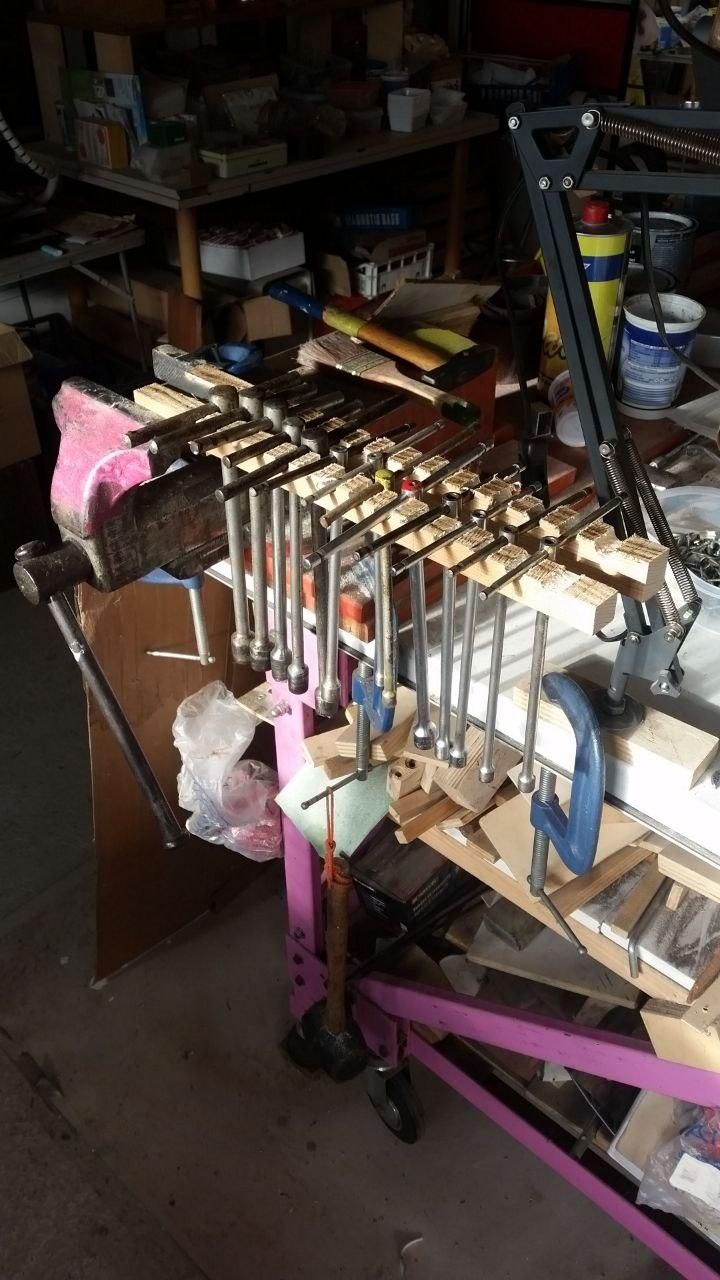 13 chiavi a T appoggiate sui supporti a culla in legno puzzolente, stretti nella morsa con uno spaziatore da 30 mm.