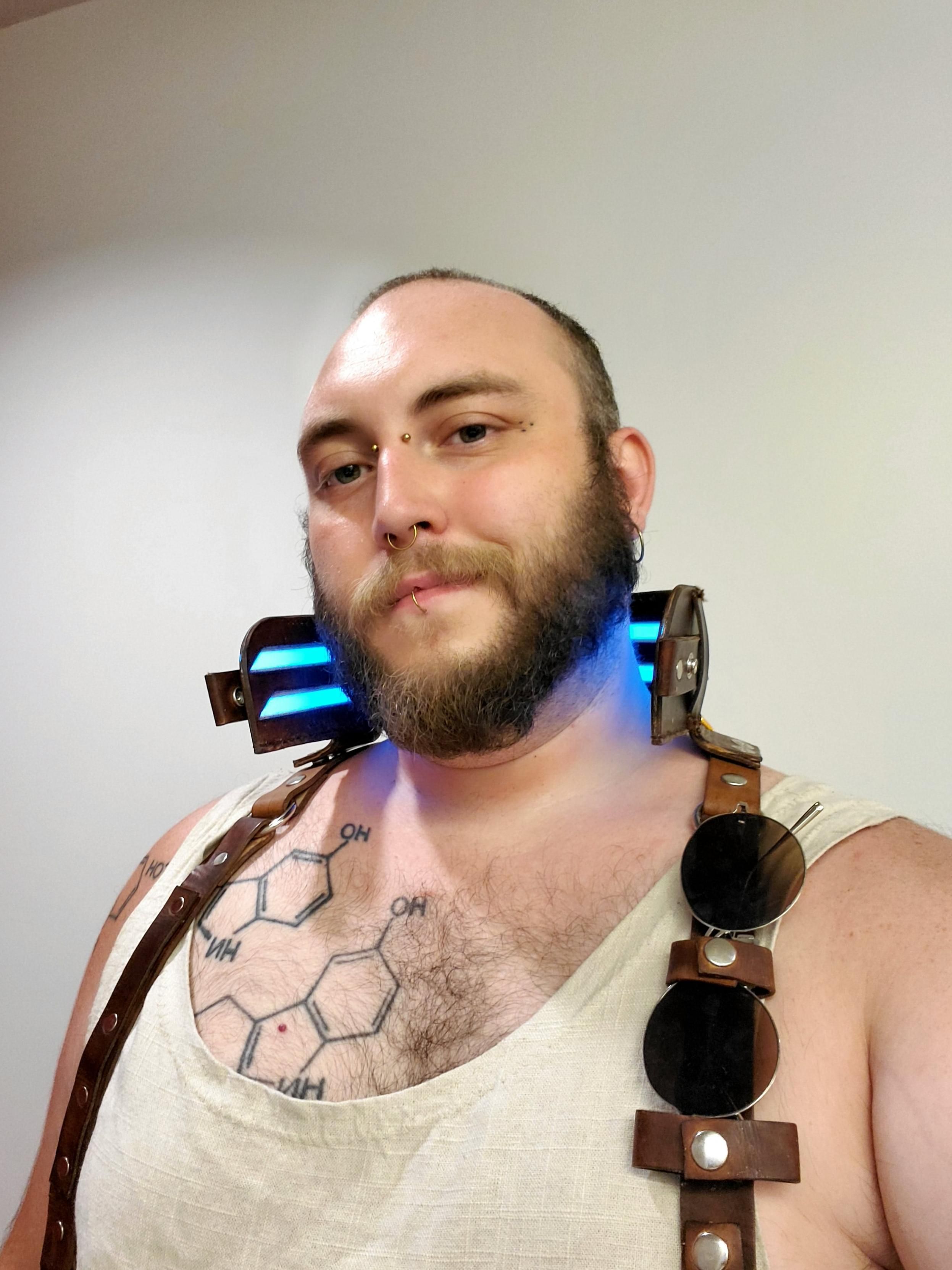 Selfie. A brown leather high-collar stands up behind my neck, glowing blue from EL strips. 