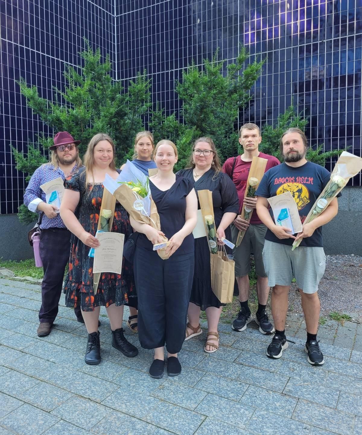 Finalistit valokuvassa kukkineen. Pekka Kolehmainen, Anna Metsäpelto, Erika Lantz, Maiju Ihalainen, Susanna Rajanen, Tapani Iivanainen ja Lassi Väänänen. 