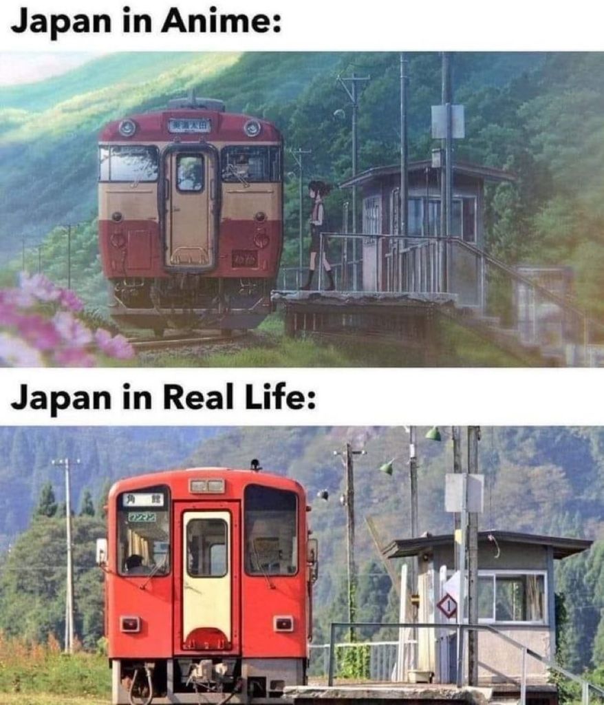A comparison meme showing two images of a small train station in a rural, hilly area.

Top Panel: Labeled "Japan in Anime:" shows a highly detailed, softly-lit, picturesque drawing of a red and tan train at a small wooden station platform. A girl in a black uniform is standing on the platform.

Bottom Panel: Labeled "Japan in Real Life:" shows a photographic image of an almost identical scene: a bright red train and a small, functional-looking station structure on the platform, surrounded by green hills. The two images are extremely similar, suggesting that the anime depiction is realistic.
