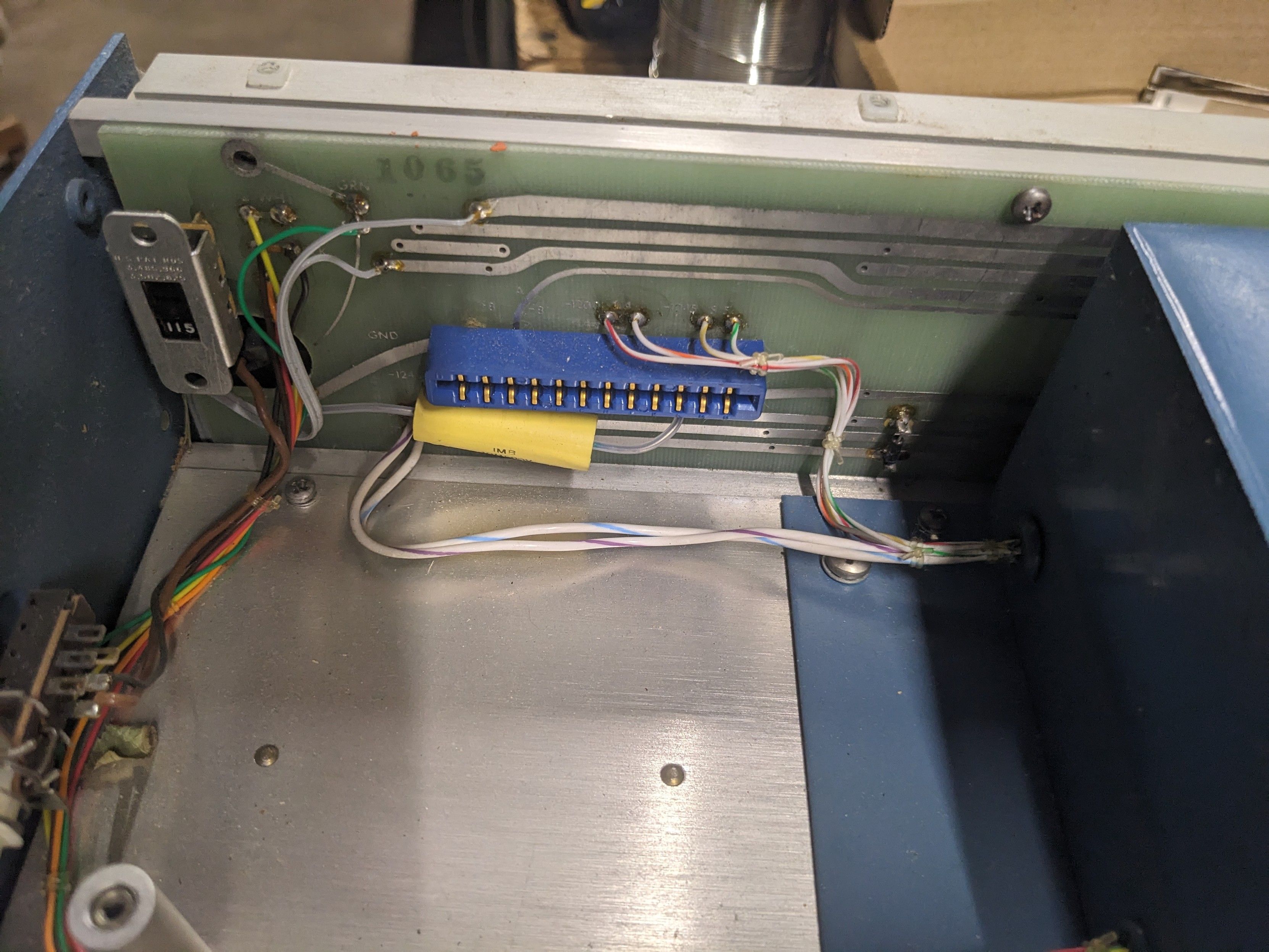 The empty slot for the card on a pcb without solder mask.  The 115/220V switch is visible, strangely positioned on the inside of the chassis and unaccessible from the outside.