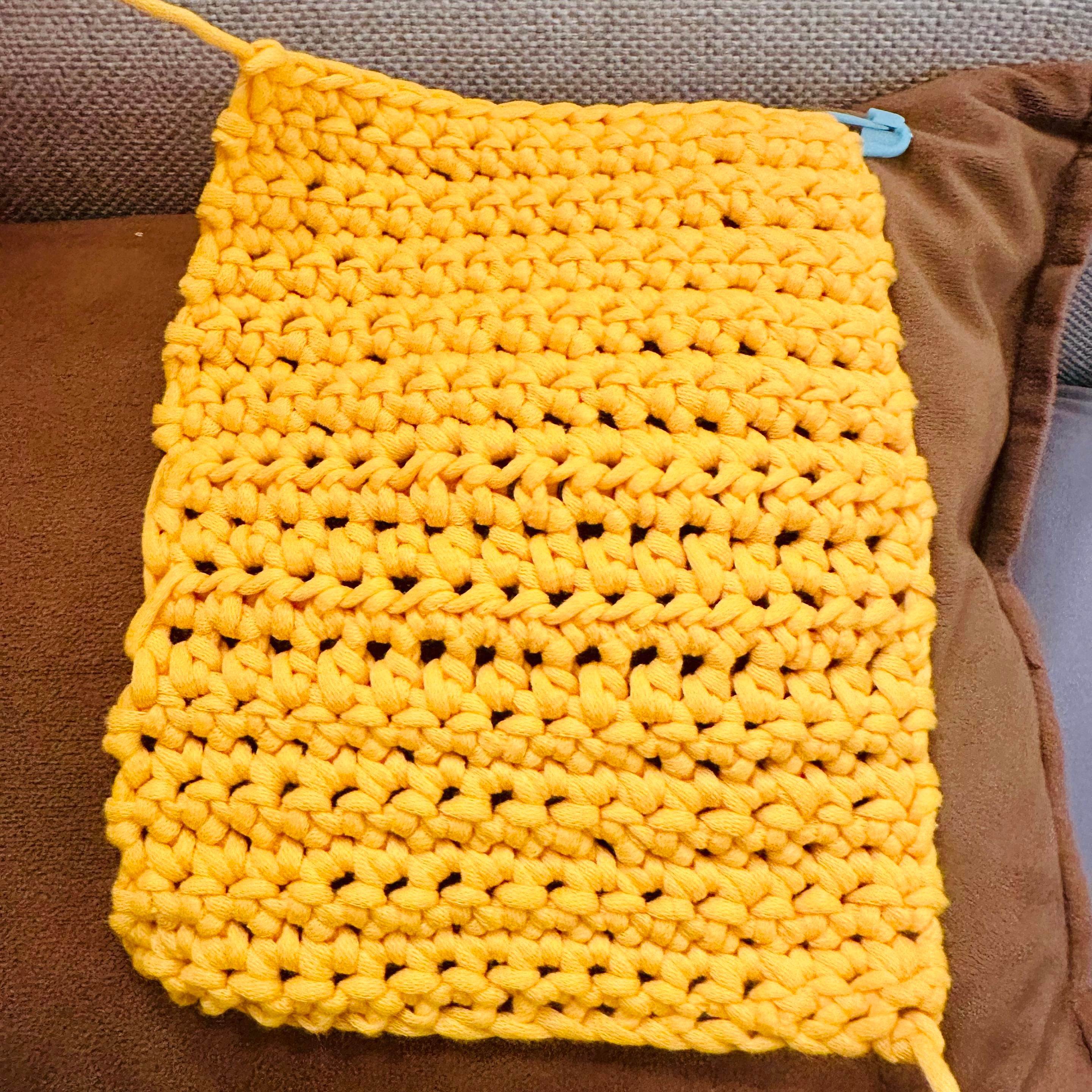 A photo of a yellow rectangle of various crochet stitches 