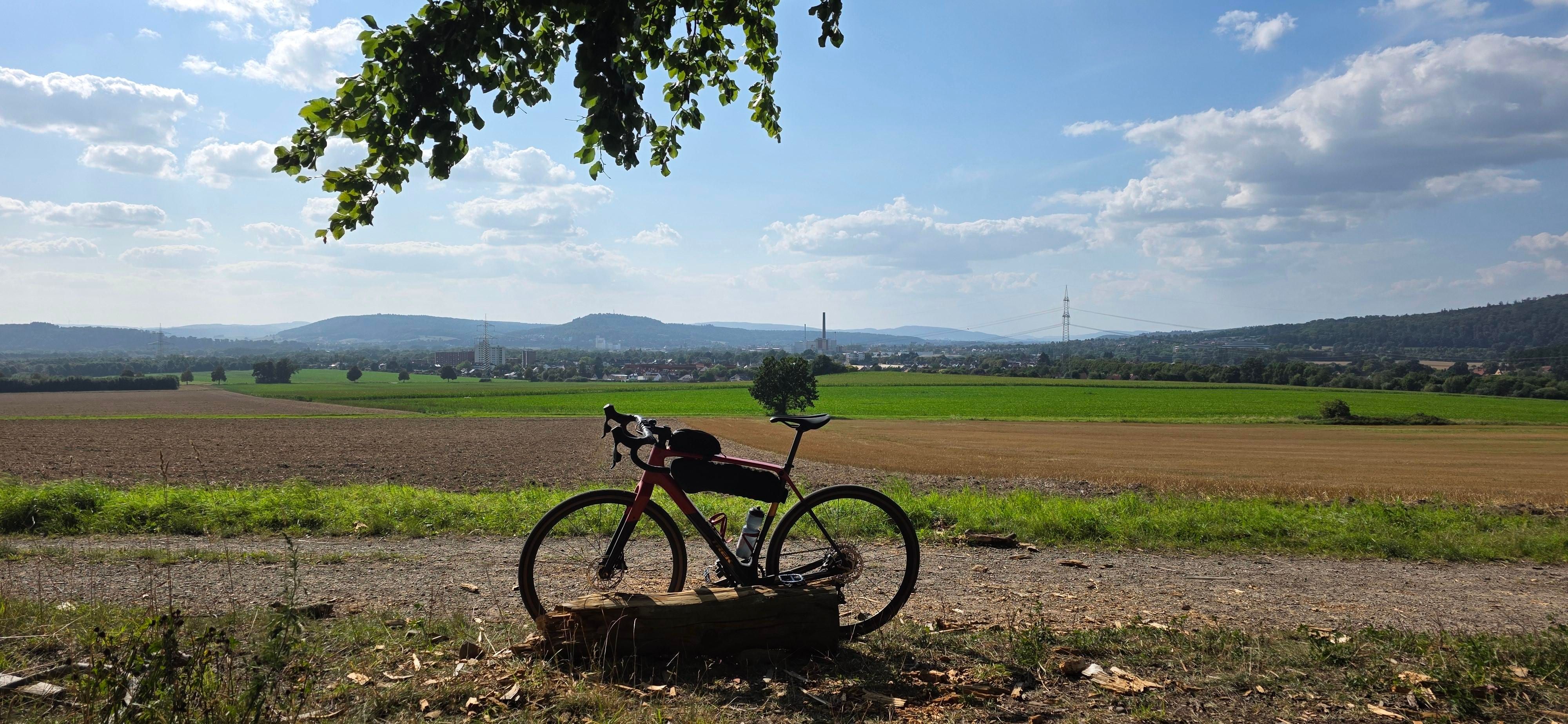 A gravel bike in front of the hills of Weserbergland on a nice sunny day. In the distance the small town Hamelin is visible.