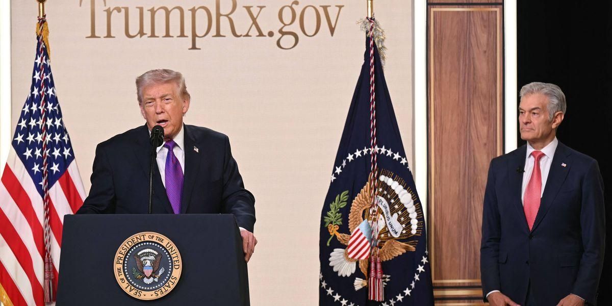 Donald Trump speaks from a podium about his TrumpRx scheme at the White House while some other plutocrat-installed spokespuppet looks on. 

(Photo by Saul Loeb/AFP via Getty Images) 
