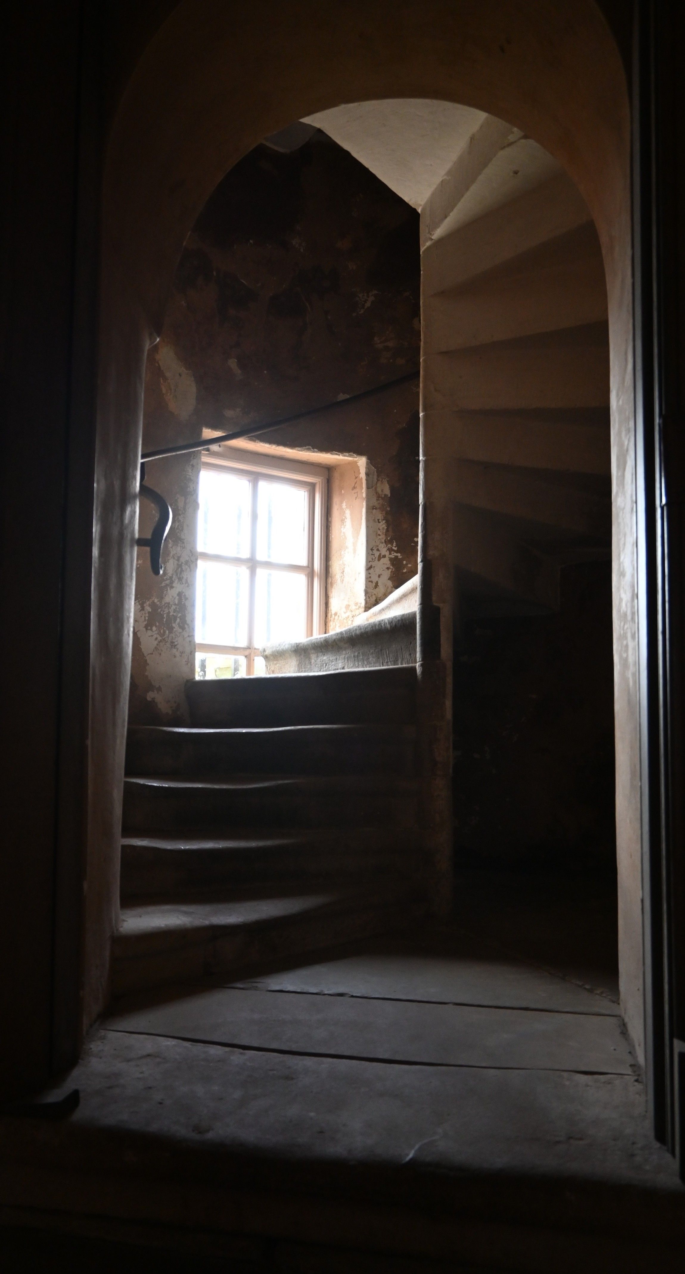 Stone staircase seen through a door. Inside a building from 1700s called the Cage at Lyme Park 