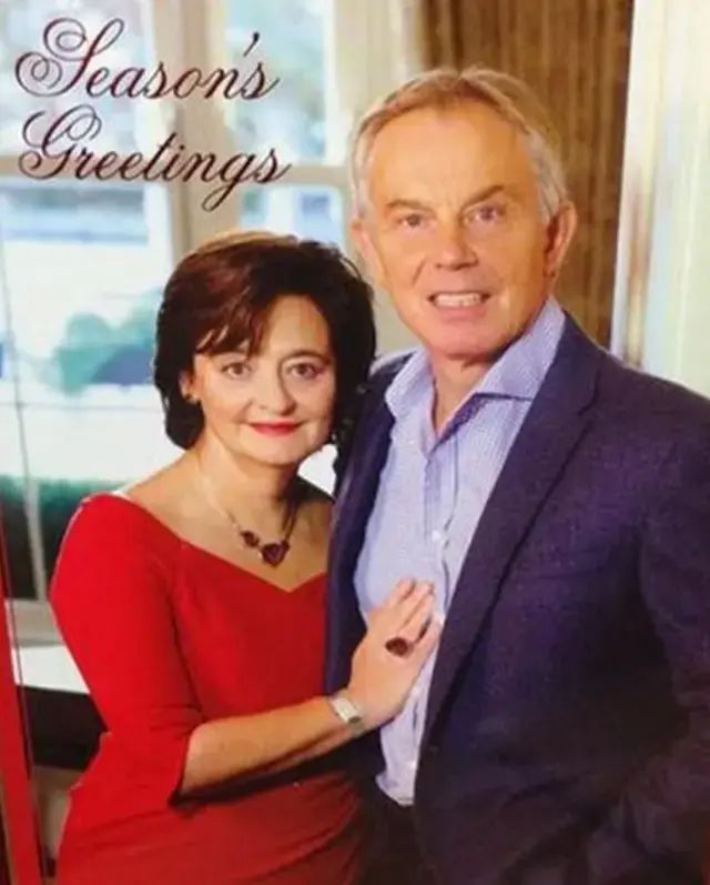OG and still the best. Tony Blair and wife Cherie pose in a way meant to convey warmth and friendliness but instead comes across as menacing. Tony looks like he'll have you. Cherie's in a nice red frock and he's in a blue suit with light blue shirt (open collar). They look like they have unlimited money and make decisions with far reaching consequences based on no evidence. 