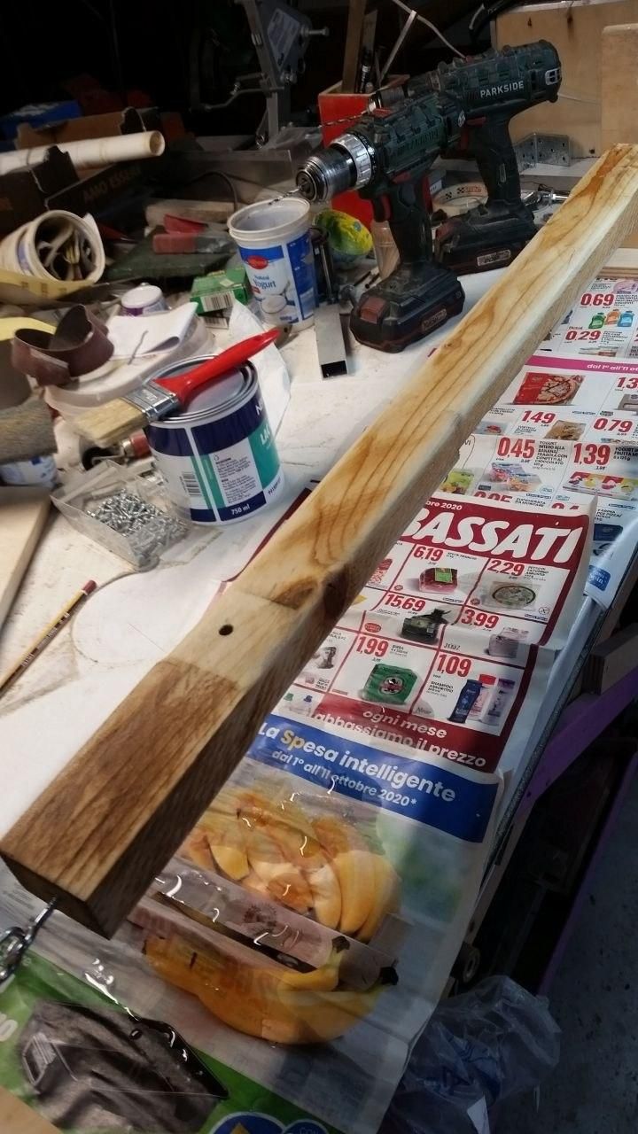 Zampa del tavolo semovente appesa tra due supporti, sopra un pieghevole Eurospin del 2020.
Si nota che il legno è stato bagnato.