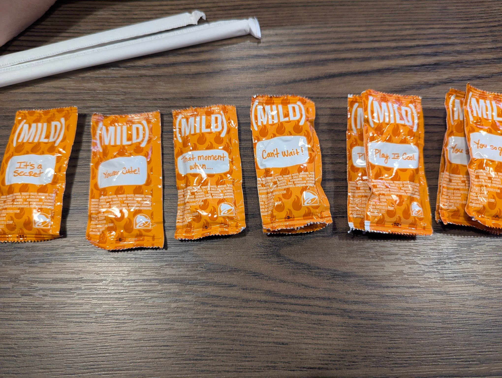 Six piles of sauce packets, sorted by the printed phrase on the package.