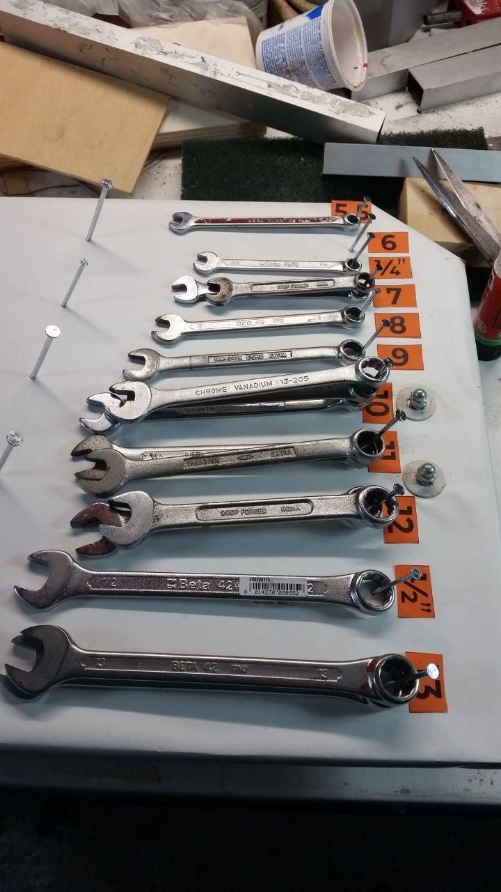 Chiavi dalla 5,5 mm alla 13 mm, comprese la ¼” e la ½”, infilate sui chiodi.
La 6 mm manca, ma prima o poi uscirà.
Ogni chiave ha la sua etichettina arancione con la misura.