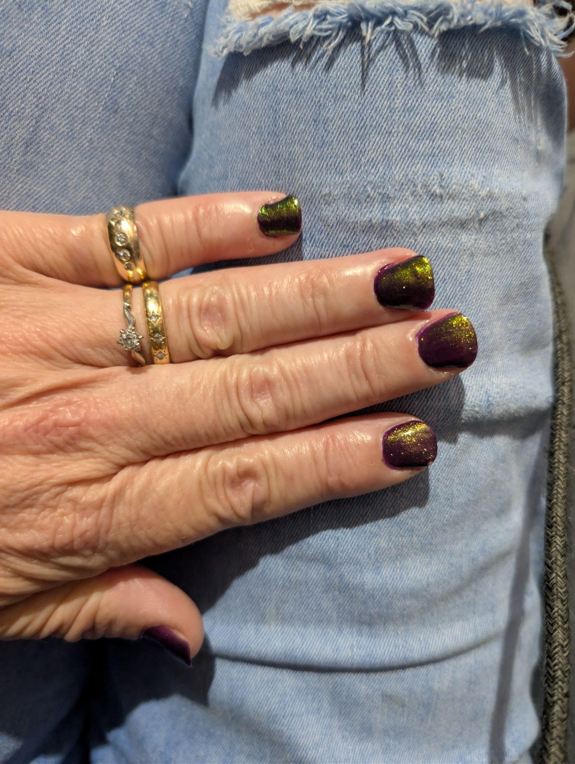 Shimmering plum nail polish on my fingers