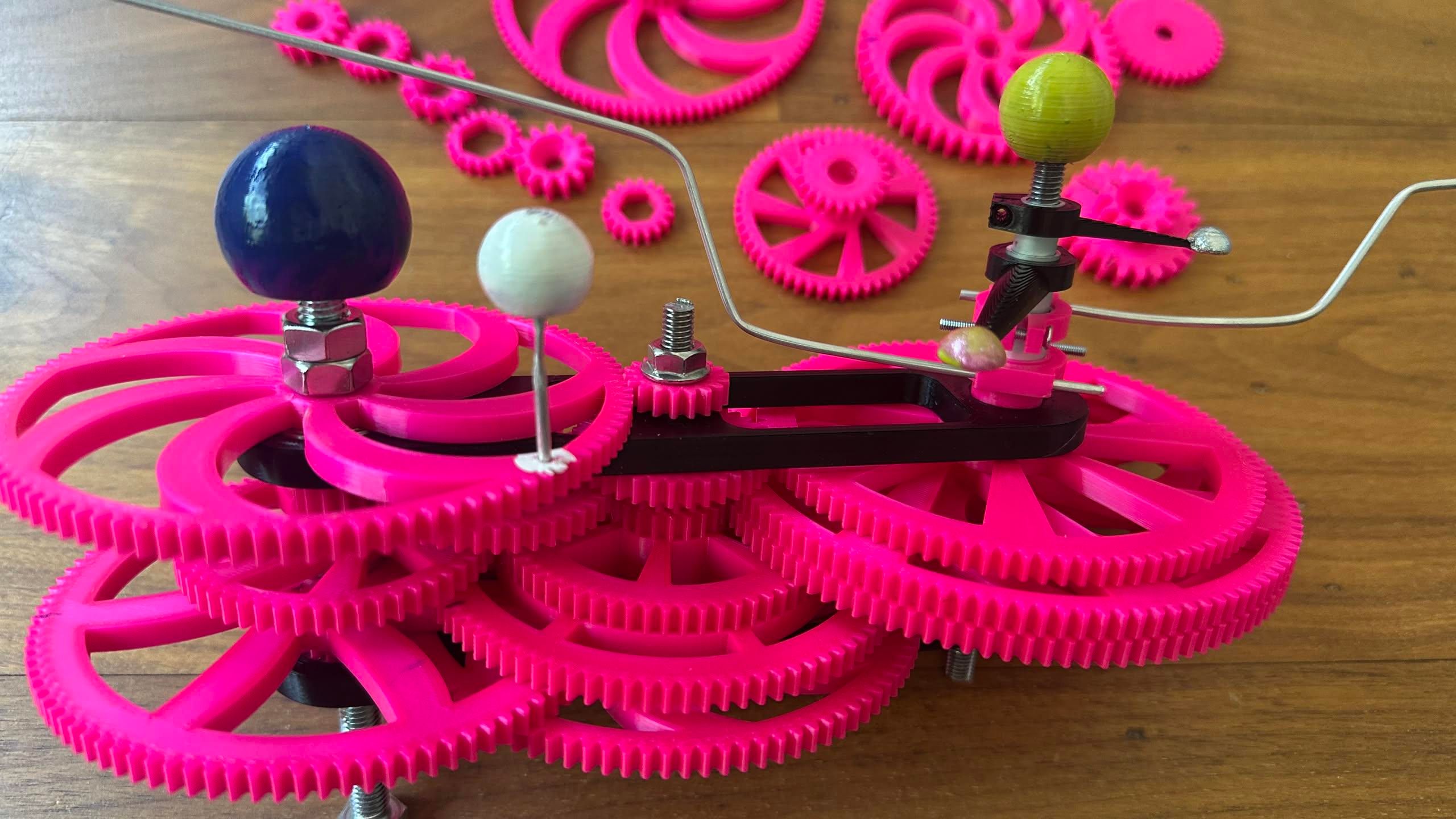 3d printed orrery with a blue sphere for earth, white for the moon, yellow for the sun, silver for mercury and yellow/pink to venus.  rods go to the sides for Mars and Jupiter.