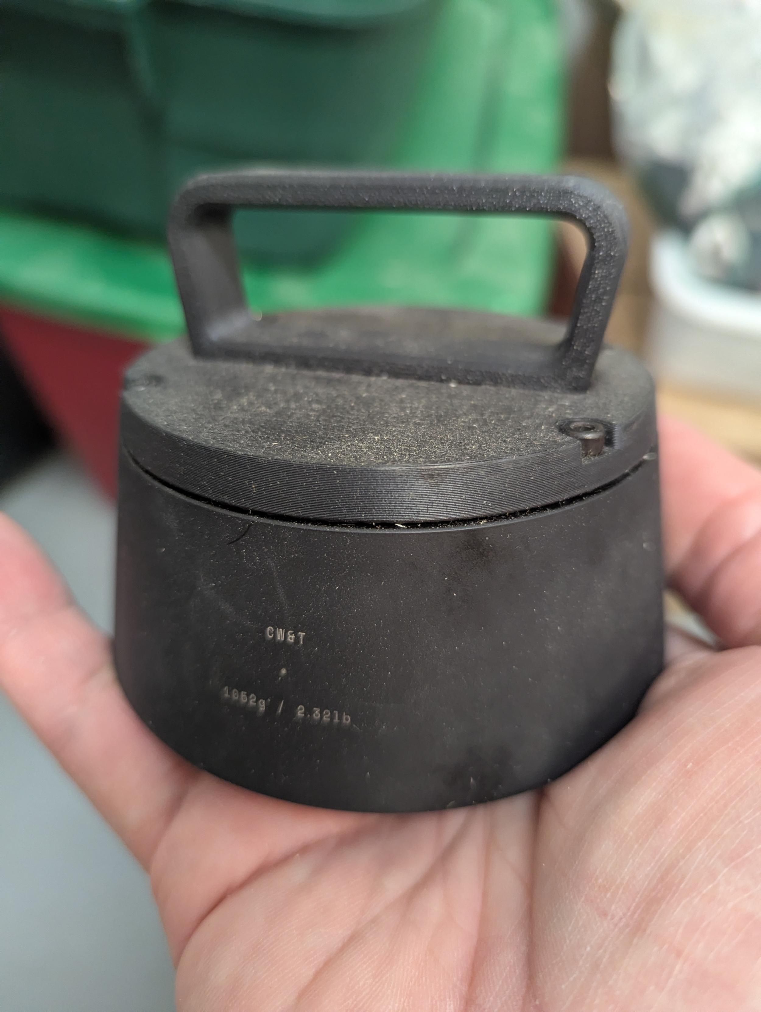 A cute little weight with a handle on top. It sort of looks like a squat kettle bell, but small.