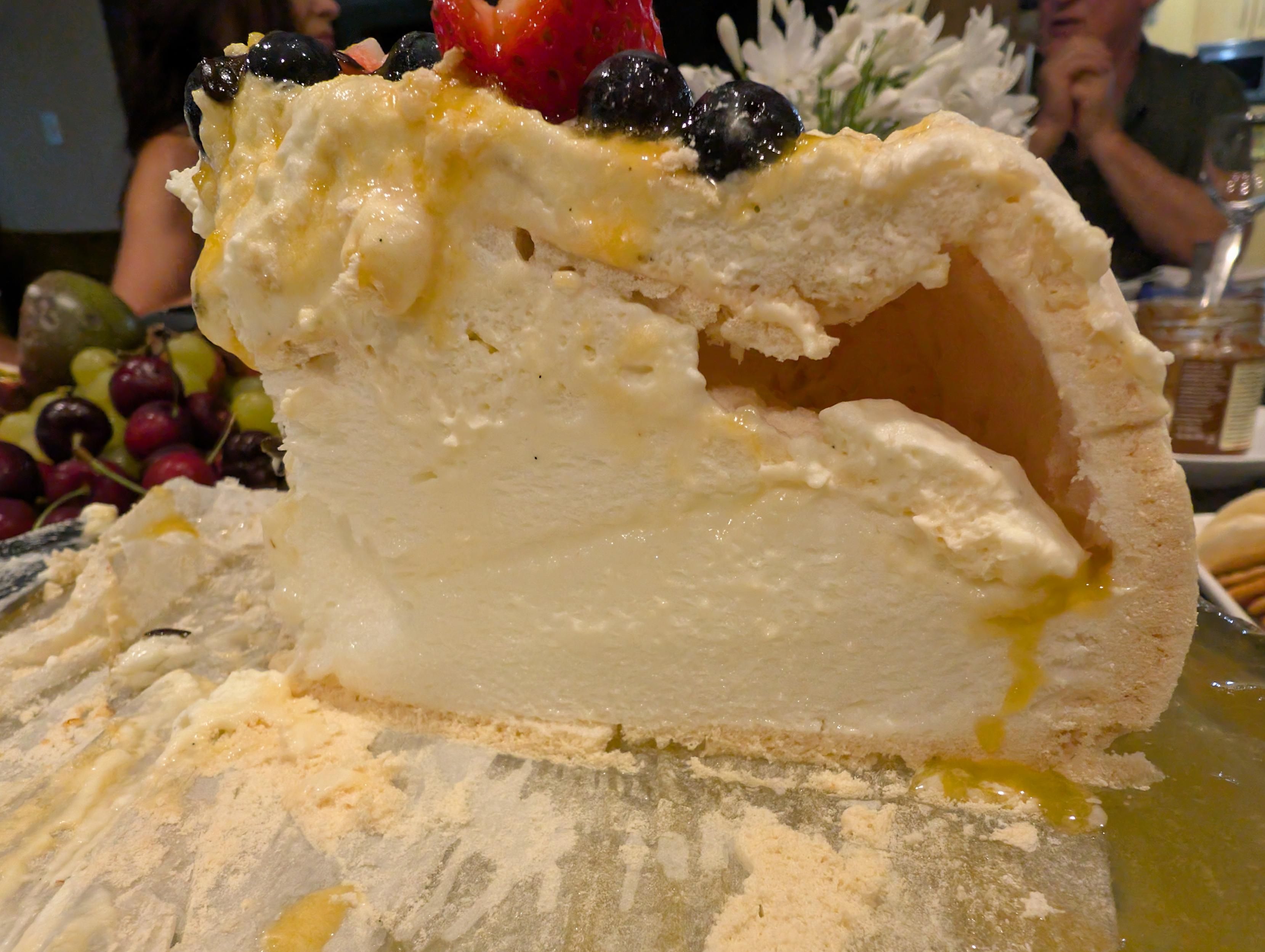 Cross section of pavlova crispy and creamy middle 

With fruit strawberry and blueberry