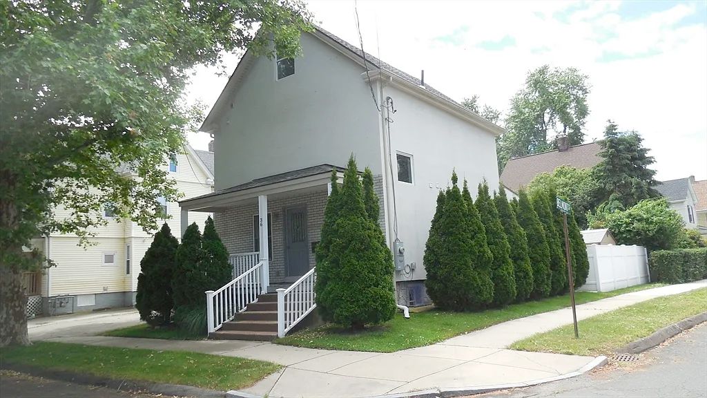 A 2 story house which barely has any windows at all, and large expanses of empty wall. There is a small window in the attic and only one on the side of the house. 