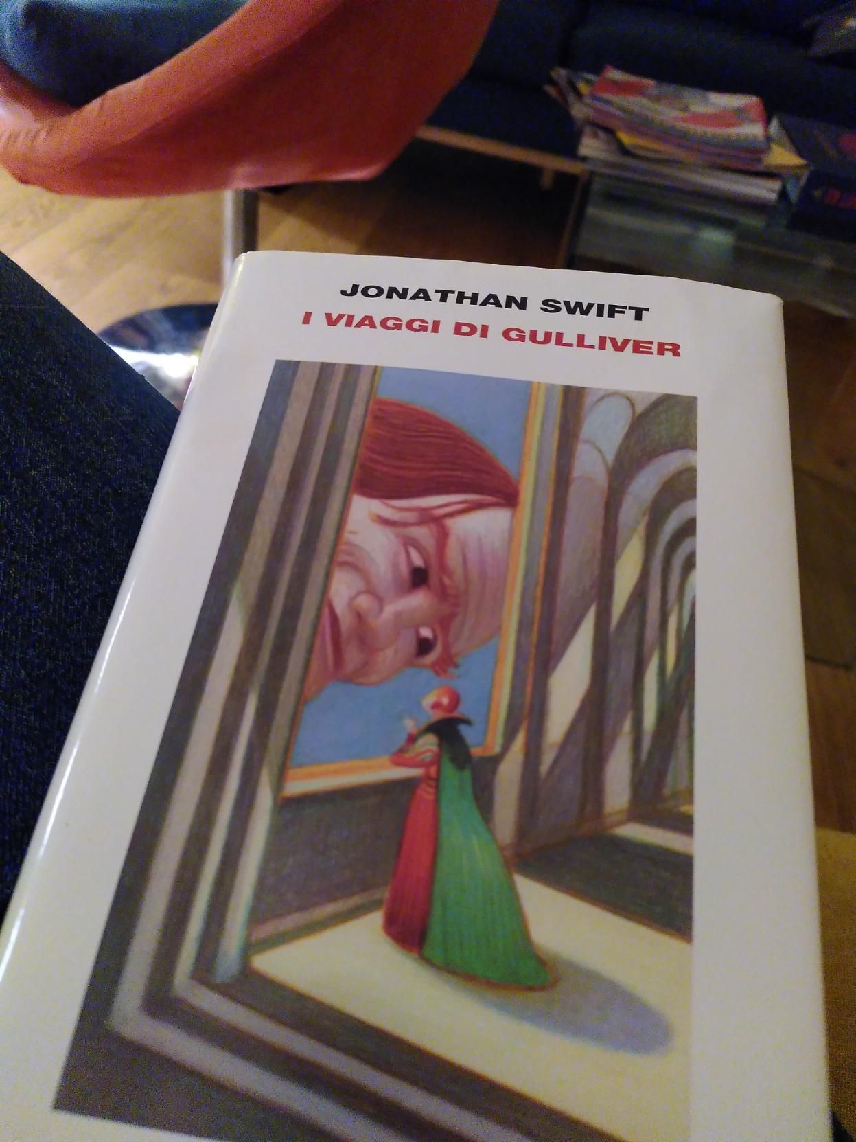Copertina di I viaggi di Gulliver di Jonathan Swift, Einaudi.
L'illustrazione di Mattotti mostra il viso di Gulliver che fa capolino da una fienstra e sorride a una donna affacciata (è l'imperatrice di Lilliput), dietro di lei si intravedono grandi archi. Dietro il libro si vede una parte di casa mia un po' in disordine: riviste su un tavolino, un divano blu e una poltrona rossa.
