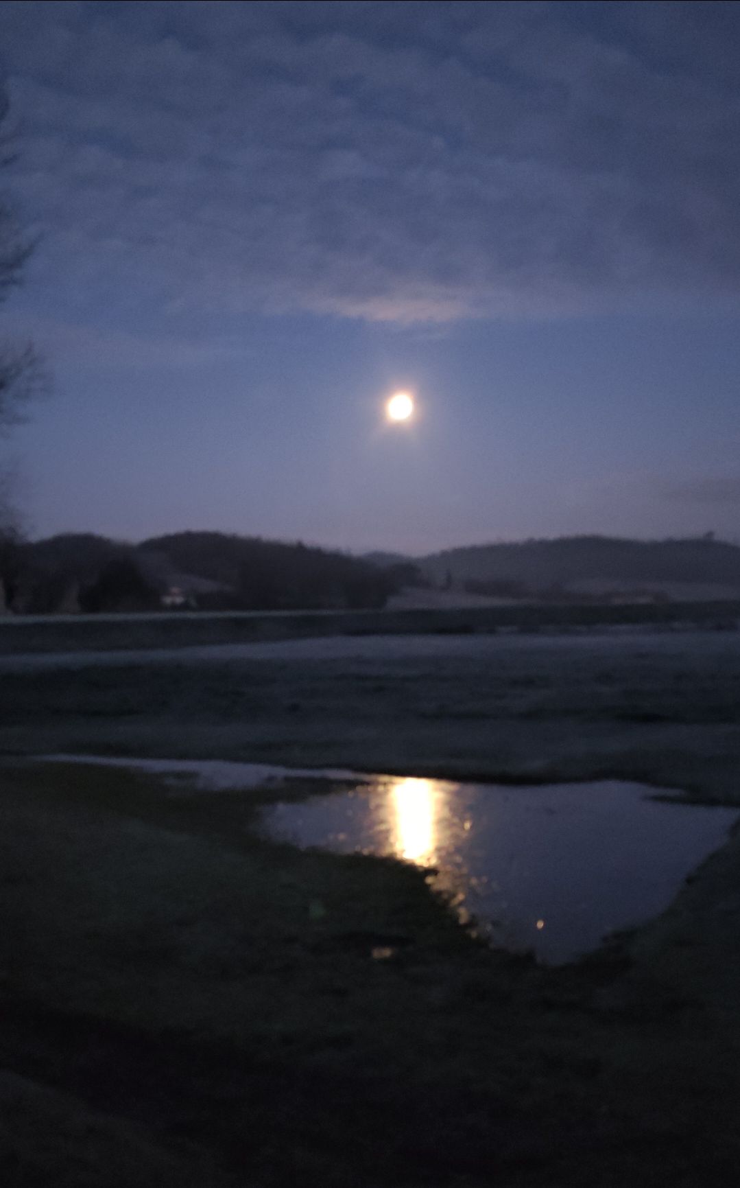luna piena che si riflette sull'acqua ghiacciata in un campo 