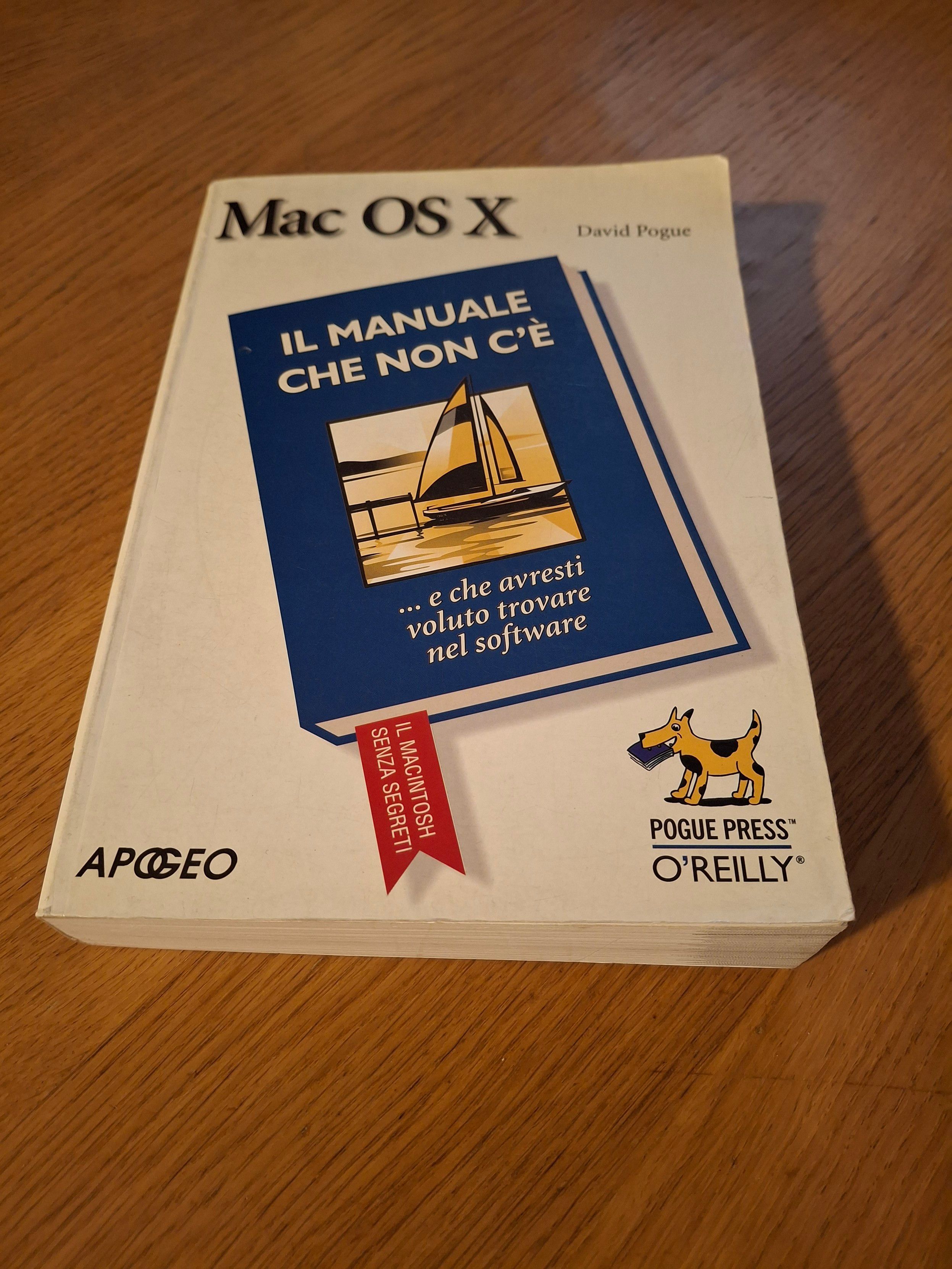 Su un tavolo di legno chiaro, un libro dal titolo "MacOS X 
(di) David Pongue, IL MANUALE CHE NON C'È... e che avresti voluto trovare nel software. Il Macintosh senza segreti.
Apogeo - Pogue Press O'Reilly"