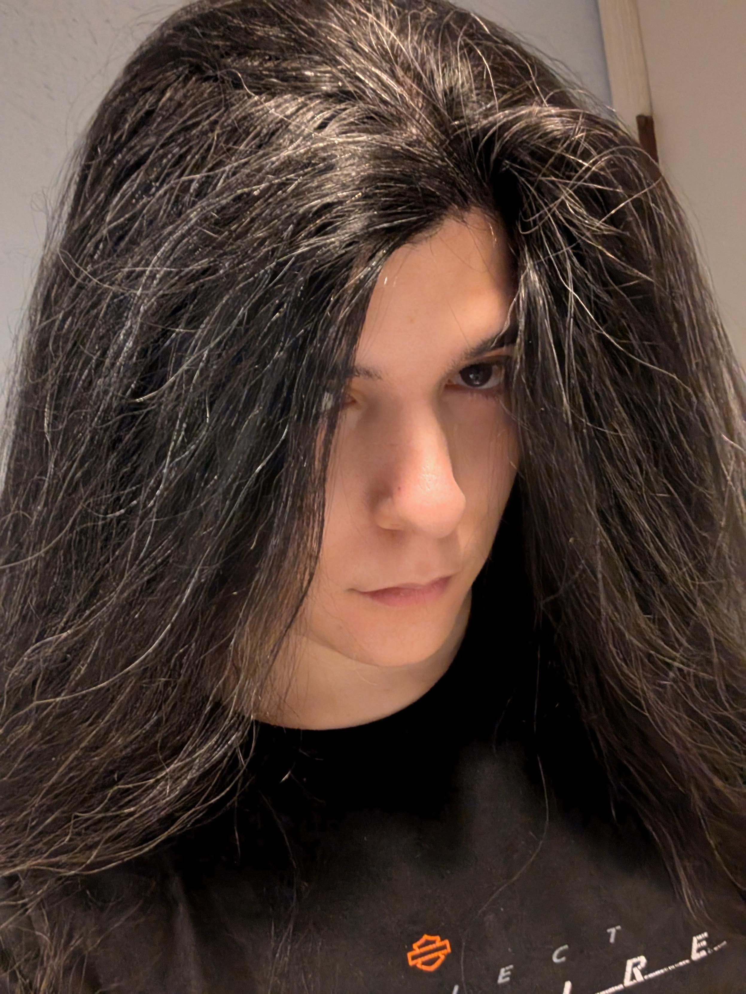 kira selfie. its hair is enormous and its gaze appears out of it as though from within a dark shroud