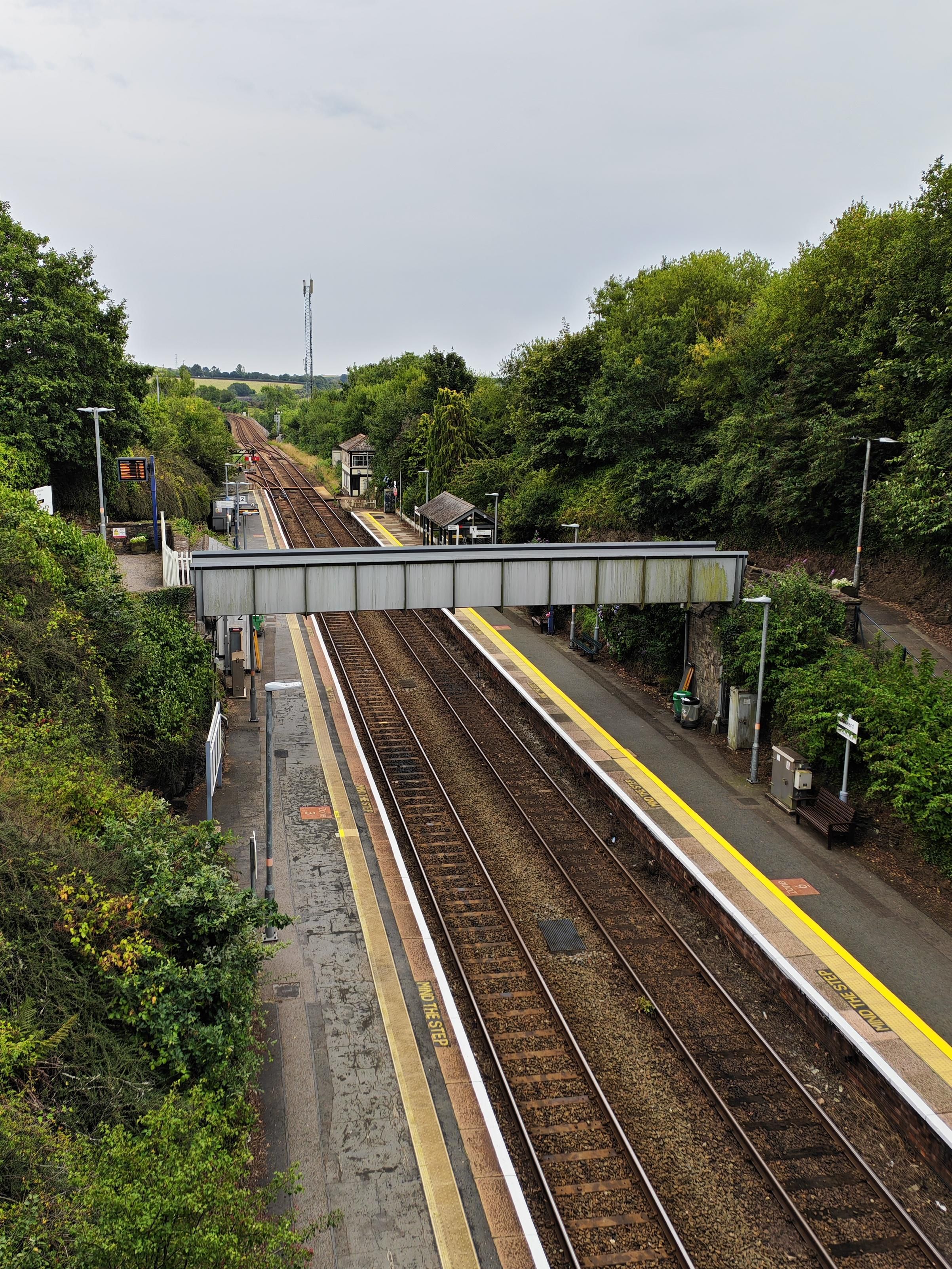 A view from the bridge, looking at Liskeard station. The line is very straight. A notable feature is the early signal box