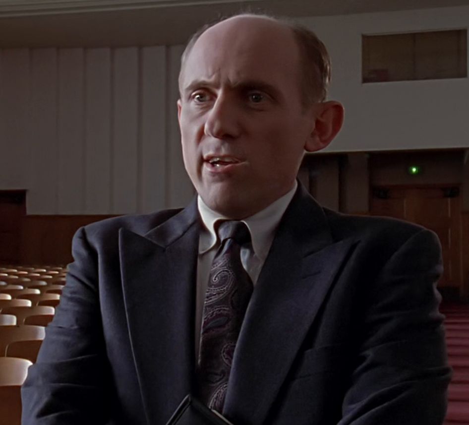 Screenshot from s01e09 Buffy The Vampire Slayer, showing Quark(Armin Shimerman) from DS9 wearing atypically bland clothes. He's going by "Principal Snyder" for some reason. Probably some kind of scam to score latinum.