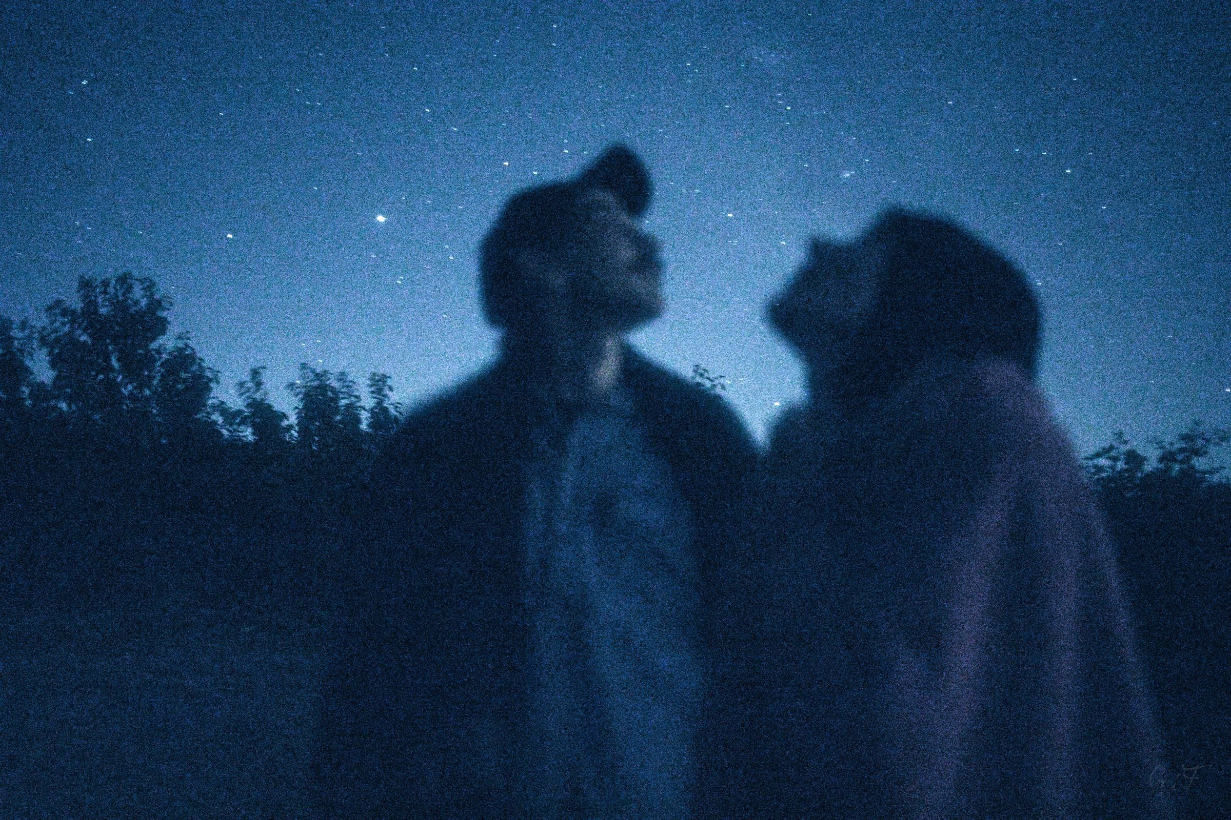 Photo of two people looking at the night sky.