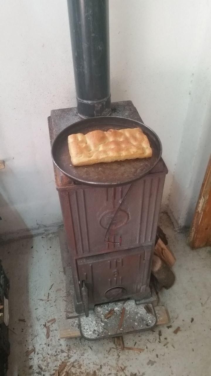 Pezzo di focaccia messo a scaldare in una teglia sopra la stufa (ovviamente accesa).