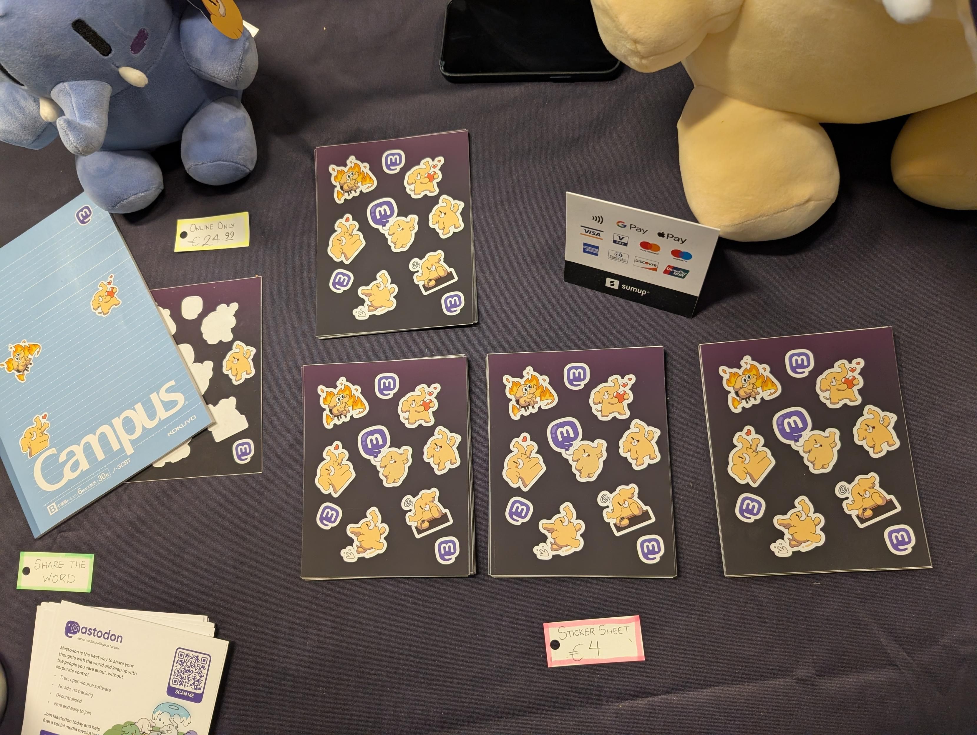 Mastodon table with several stacks of sticker sheets, and a sign for €4