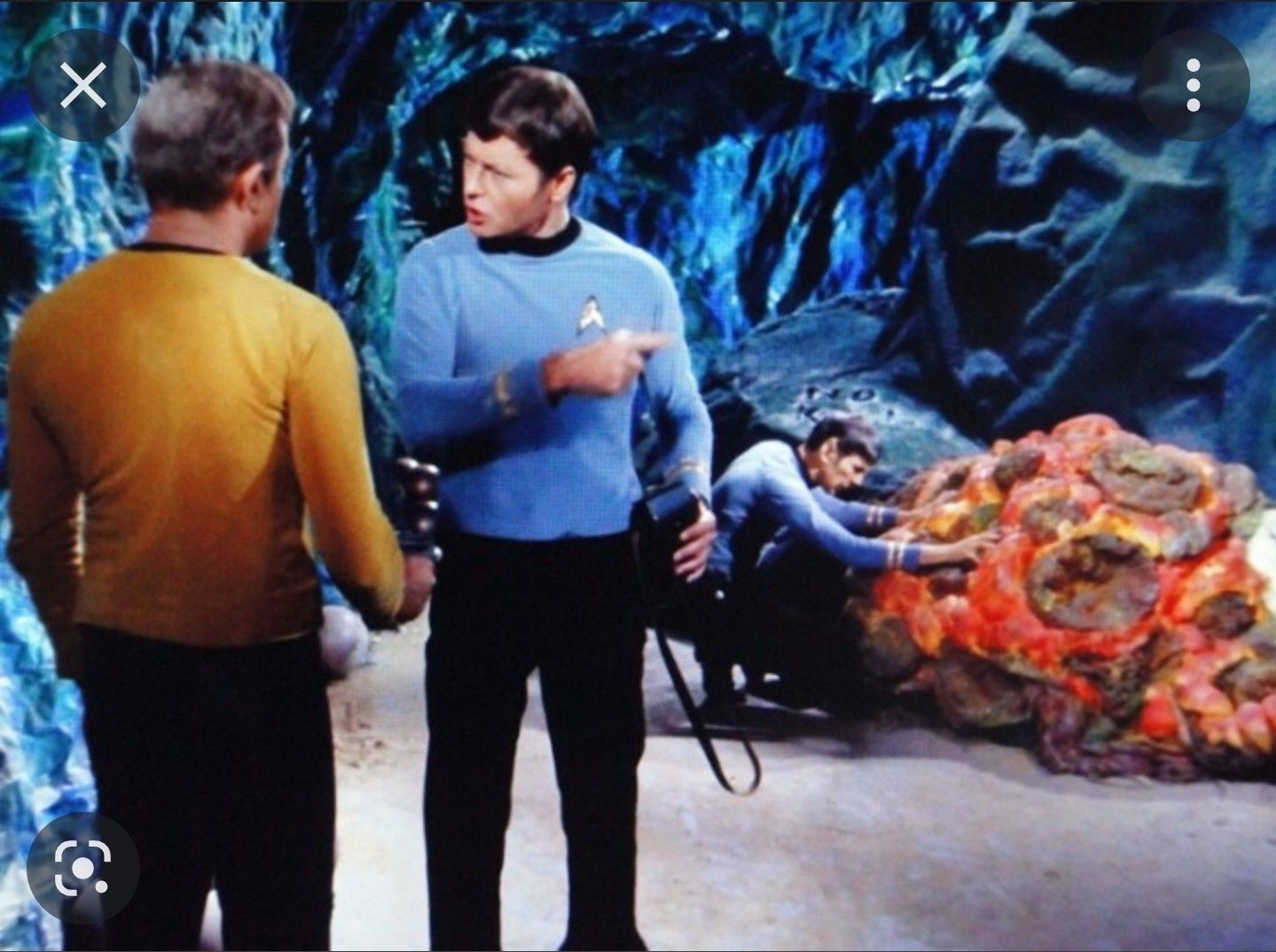 Screenshot of a horta mother communicating with Spock while Kirk and McCoy discuss the silicon-based life form.