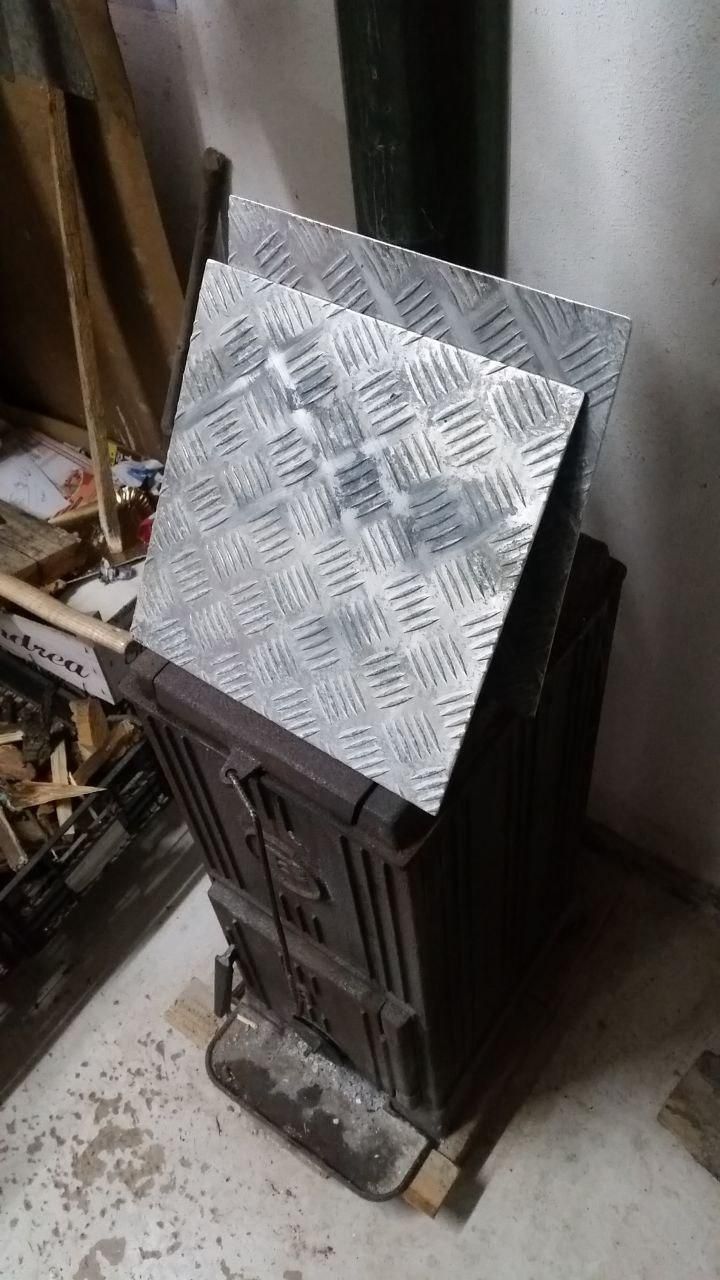 Due piastre di alluminio (non è "mandorlato", è un'altra parola che non ricordo) da 30×30 cm appoggiate sulla stufa, che non si vede ma è accesa.