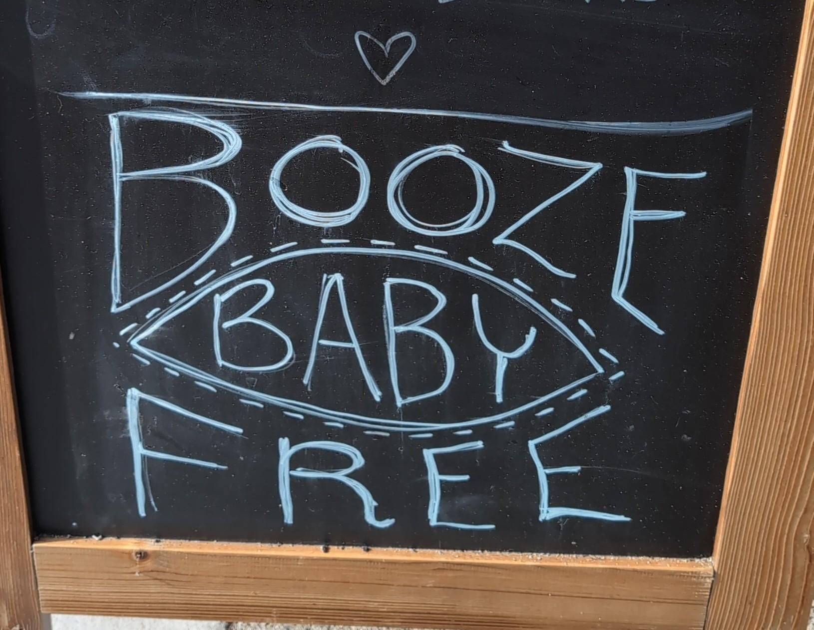 a hand written sign that says BOOZE BABY FREE