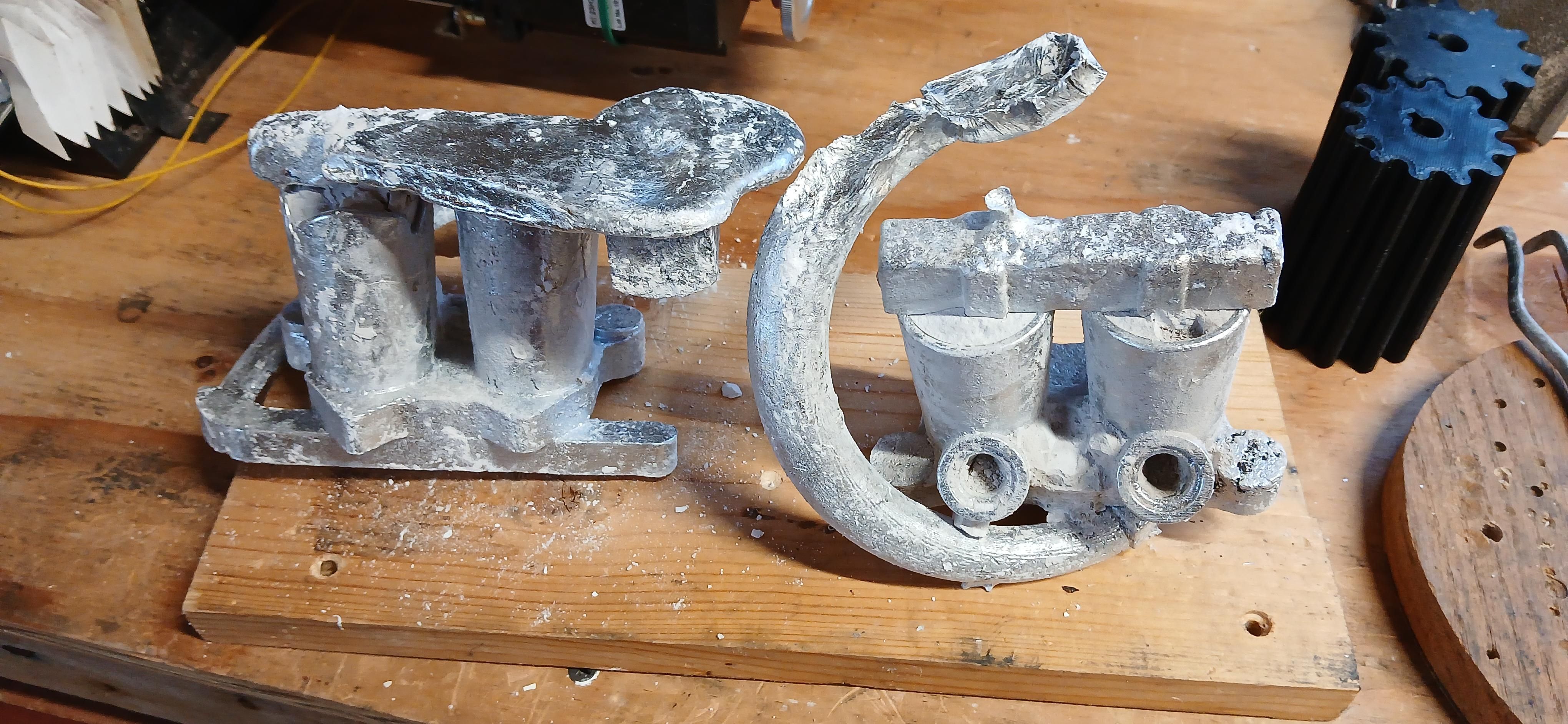 Both sides, one with the helical sprue very obvious and the almost empty pour basin above it 