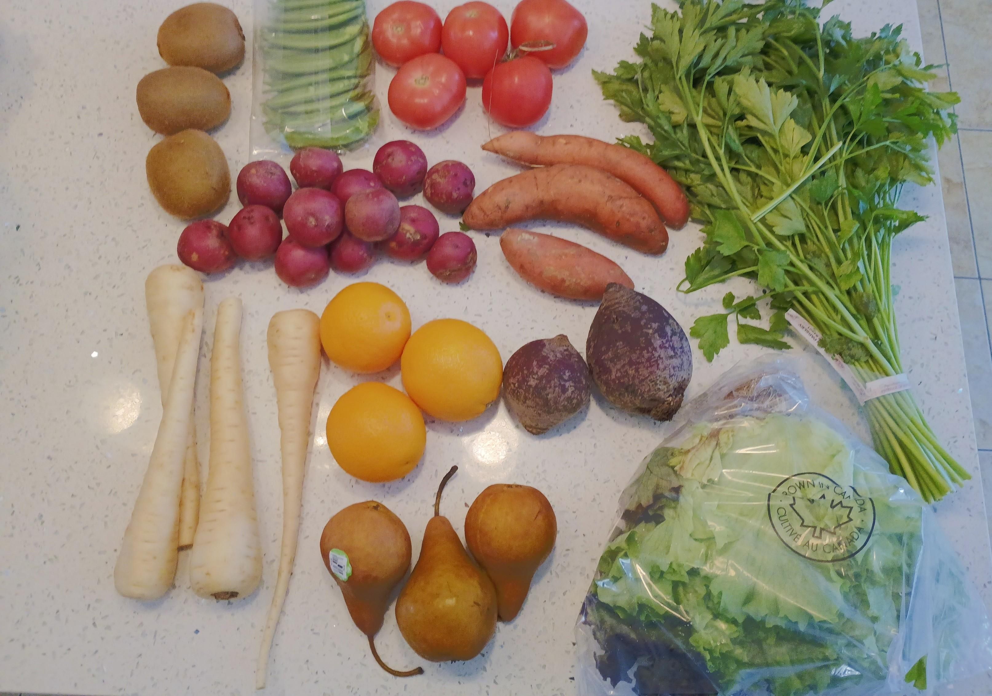 Lots of produce sitting out for a viewing. Including kiwis, peas, tomatoes, lettuce, potatoes, parsnips, sweet potatoes, parsley, oranges, beets, pears and lettuce.