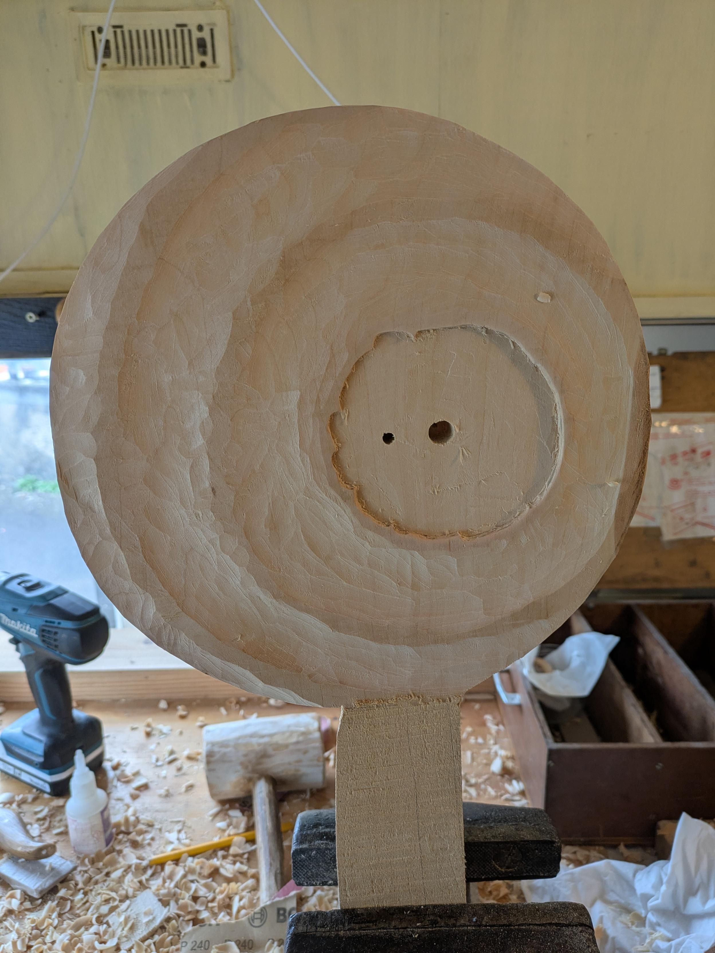 A round base with rough small waves in water. There is the pattern of the cloth and two holes for the assembly.