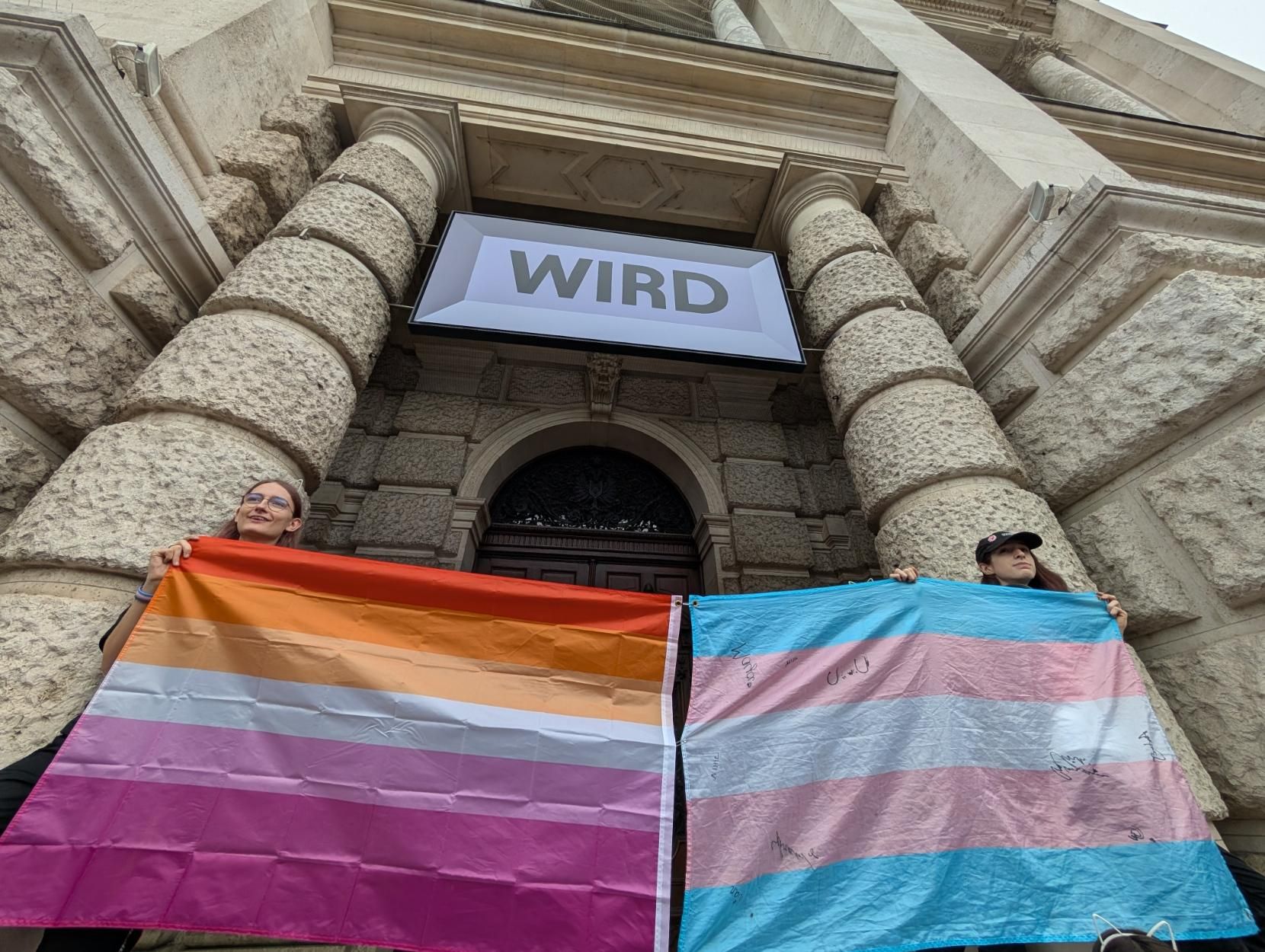 My cute cat and a friend of ours holding up flags (trans & lesbian)