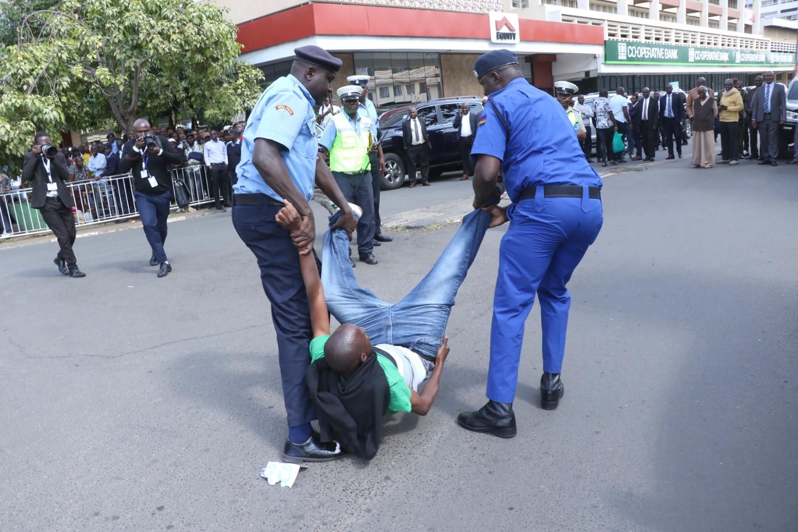 Julius Kamau was dragged by two police officers while others on lookout whilst journalists taking photos after protesting against war in Sudan and Congo. 