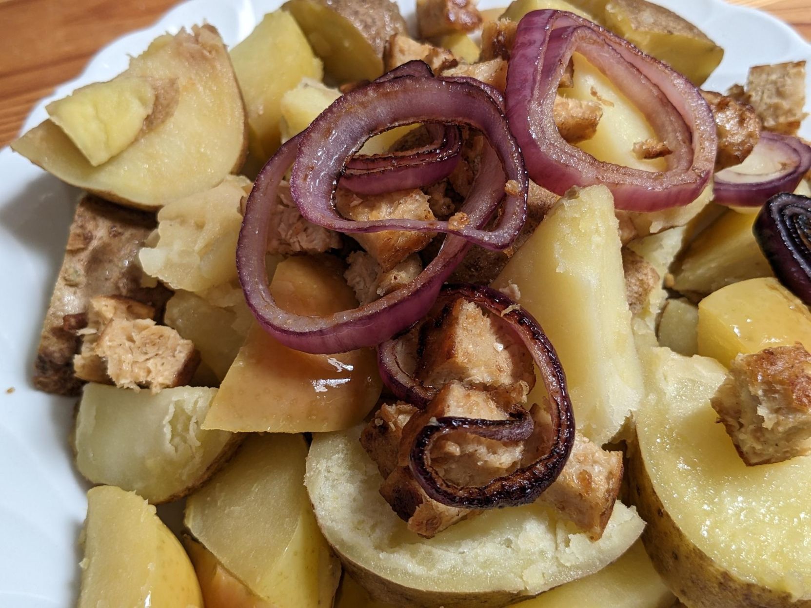 Potato and apple pieces, with fried red onions and vegan burger pieces.
