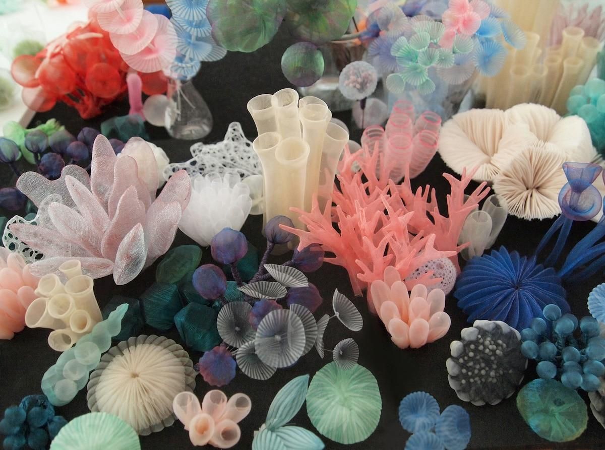 A fabric sculpture like a coral reef, soft shaped in pastel, blue and green colours. Lifelike and flowing