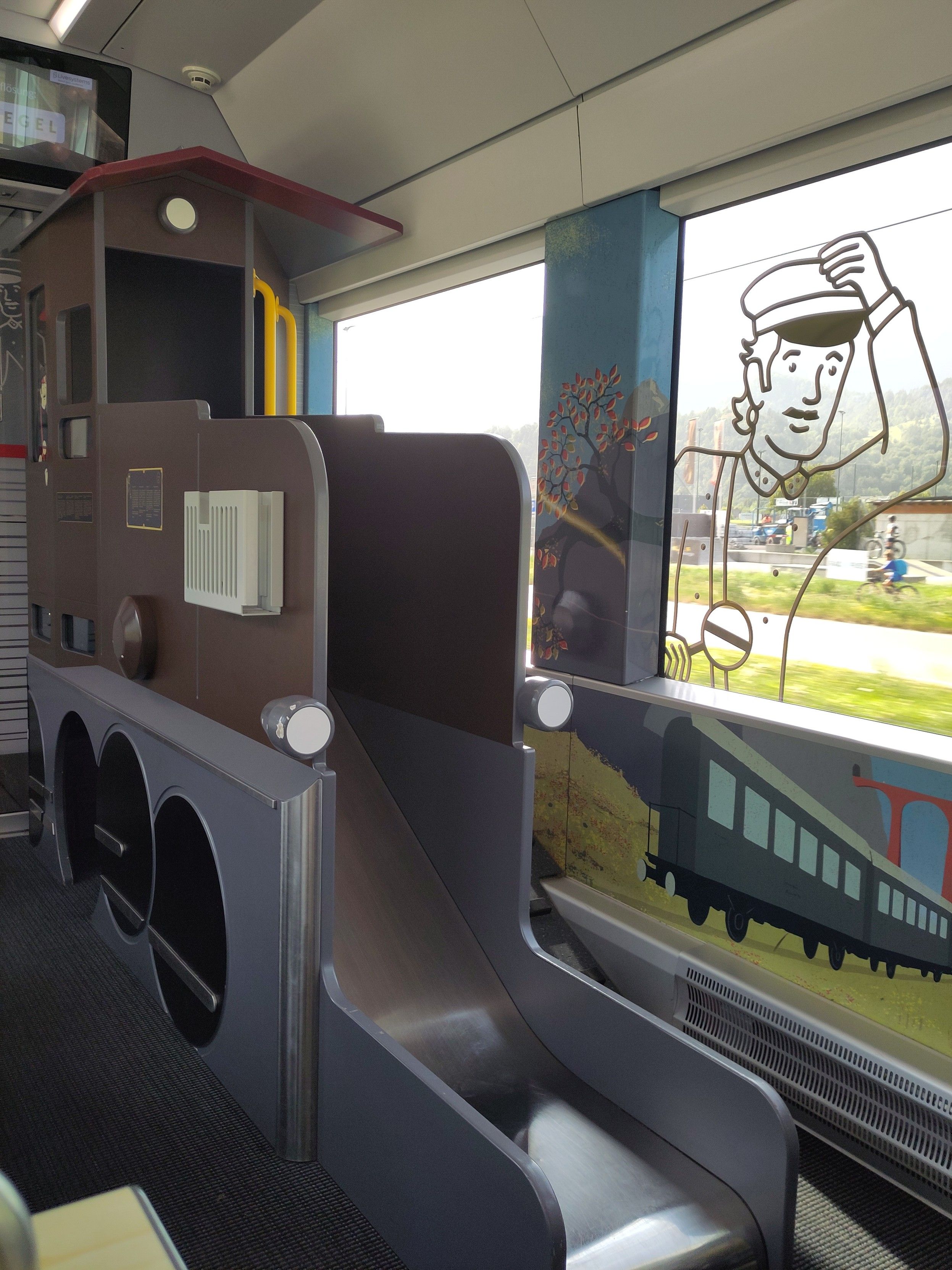 Foto. Innenansicht Eisenbahnwagen mit Rutschbahn in Form einer Lokomotive.